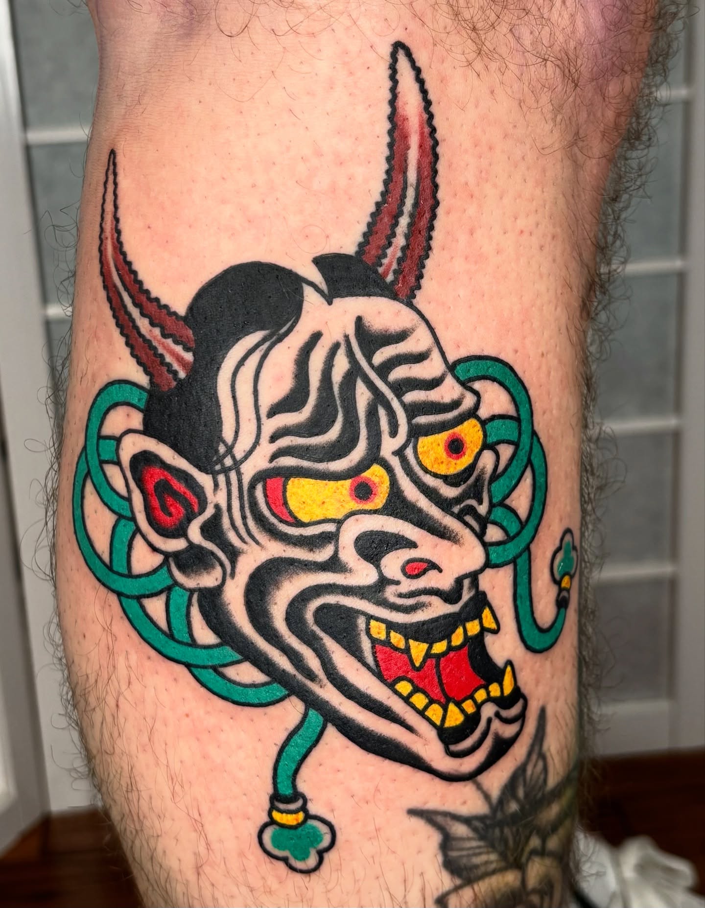Demon mask American traditional tattoo on the forearm by Santo Zelaya, San Francisco, California