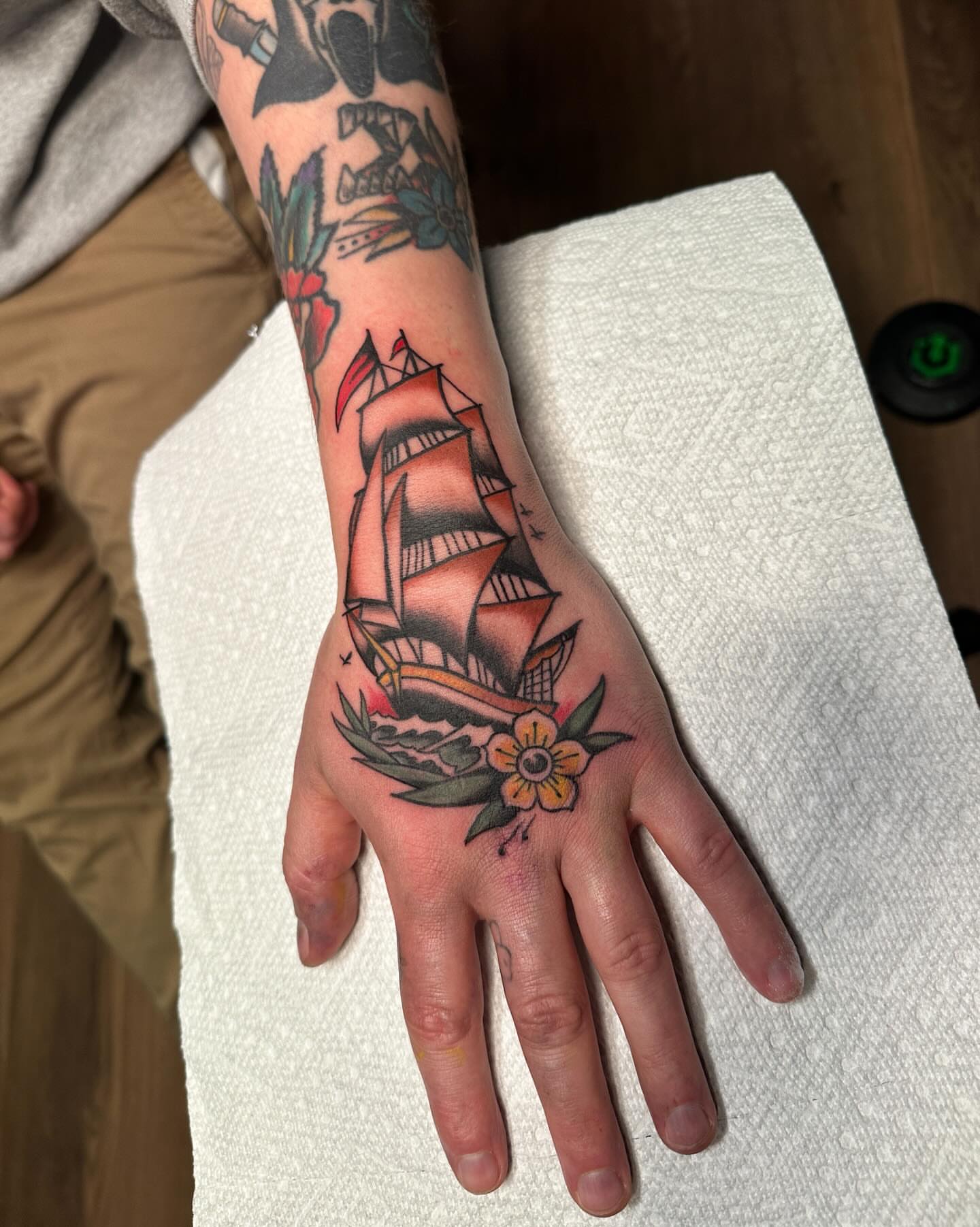 Ship and flower American traditional tattoo on the hand by Craig Ryans