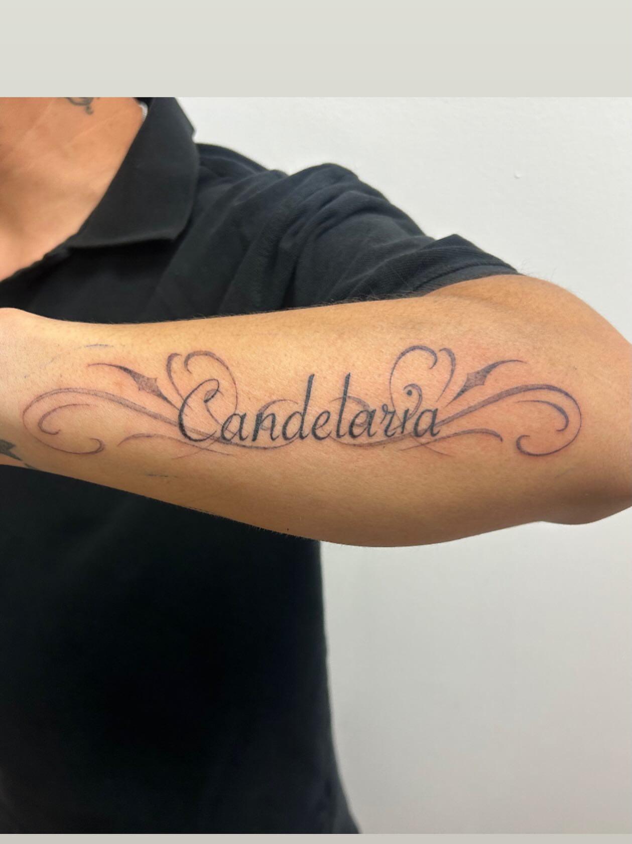 Candelaria lettering script tattoo on the forearm by Chris