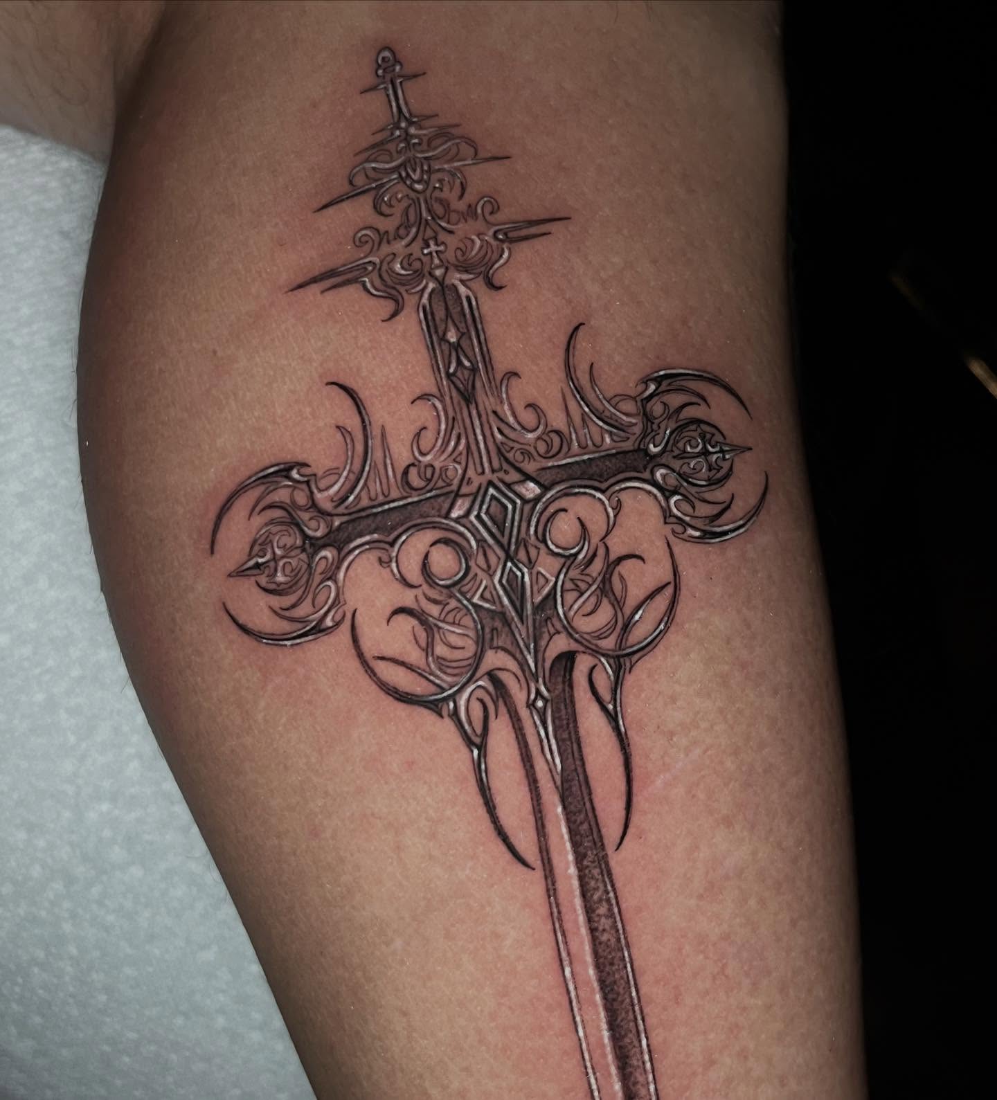Cross with sword ornamental tattoo on the forearm by Single Needle ๐ชฉ