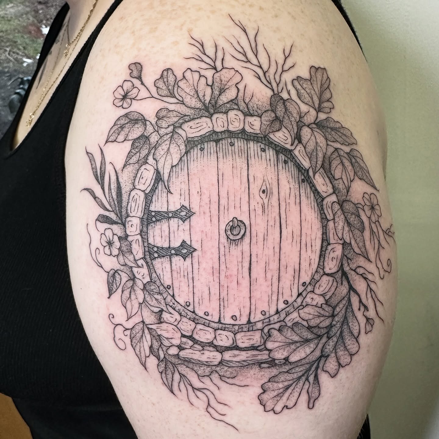 Round door with foliage dotwork tattoo on the shoulder by Robert McCollum