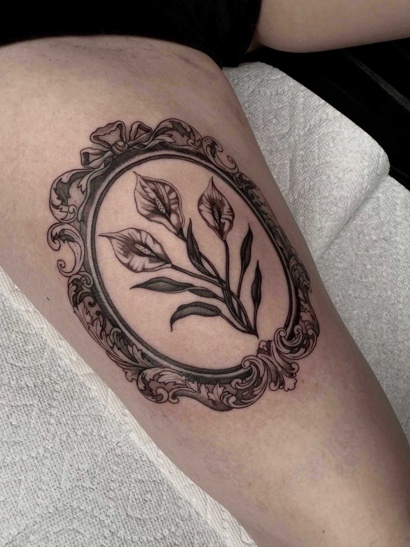 Calla lilies black and grey tattoo on the thigh by Joe Weber, Monona, Wisconsin