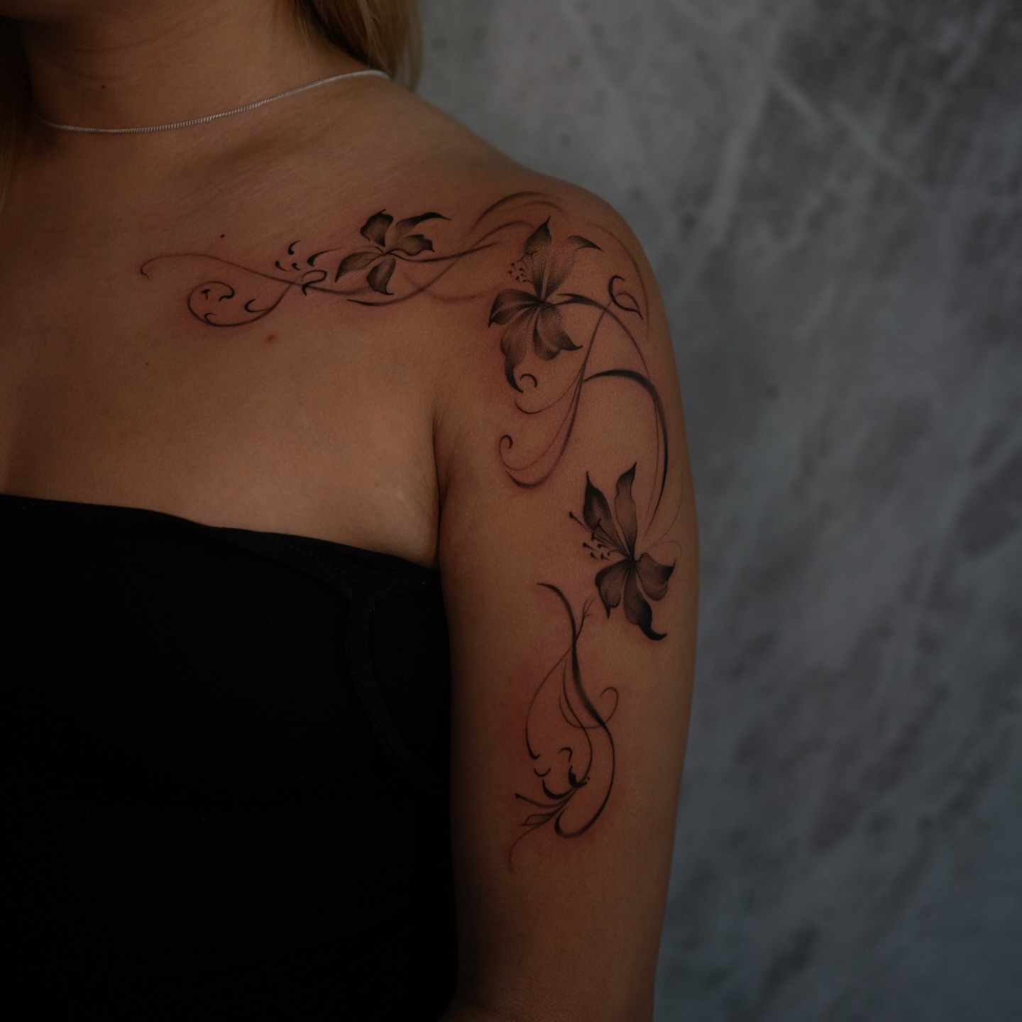Lily flowers black and grey tattoo on the shoulder by Damon Valdez