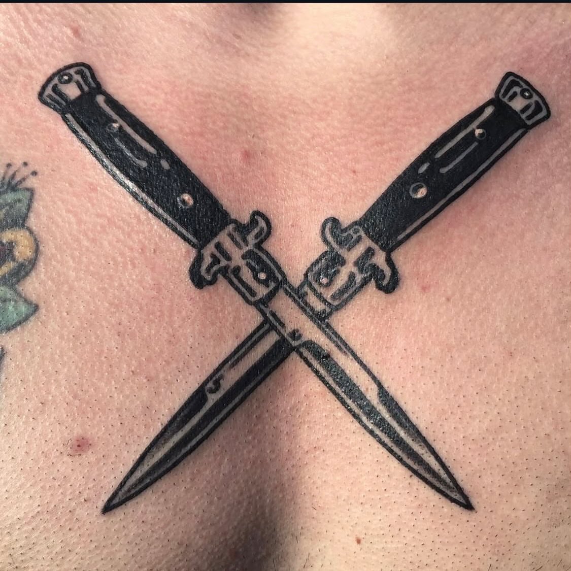 Crossed knives black and grey tattoo on the chest by Los Angeles Tattoo Artist