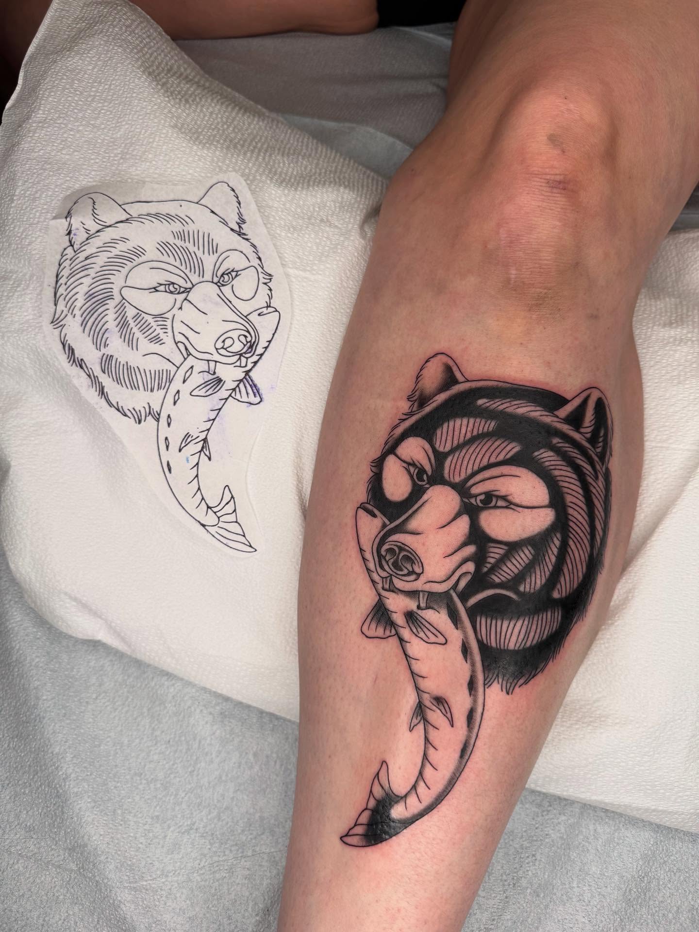 Bear and fish black and grey tattoo on the forearm by Maddie Hammell