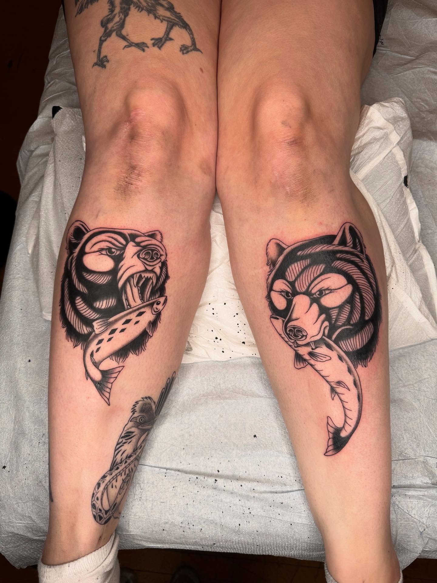 Bear and fish black and grey tattoo on the leg by Maddie Hammell