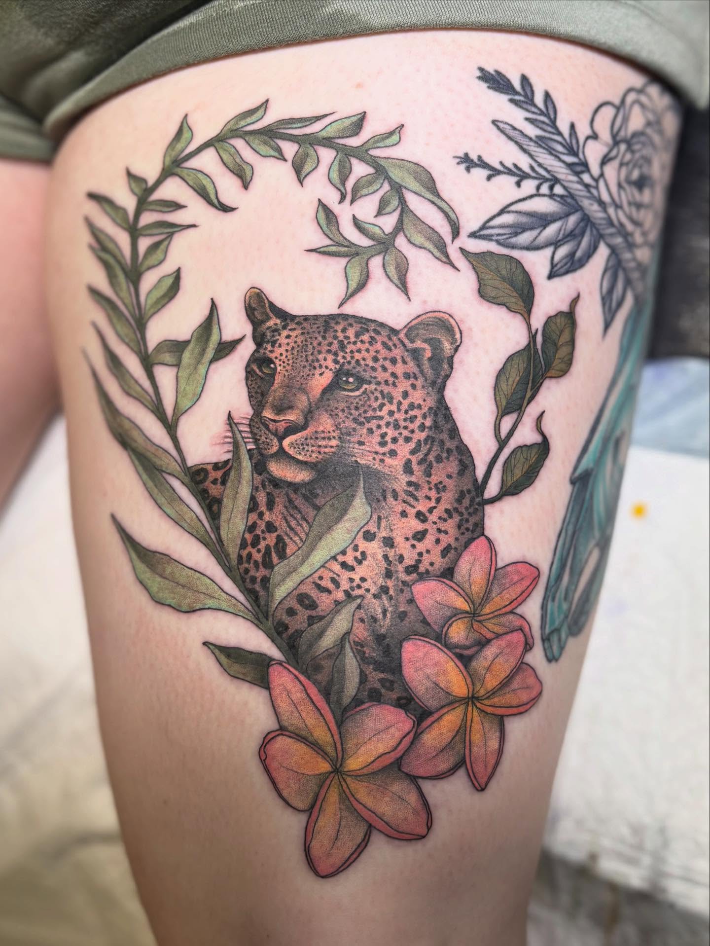 Leopard and flowers realism tattoo on the thigh by Olivia Buch
