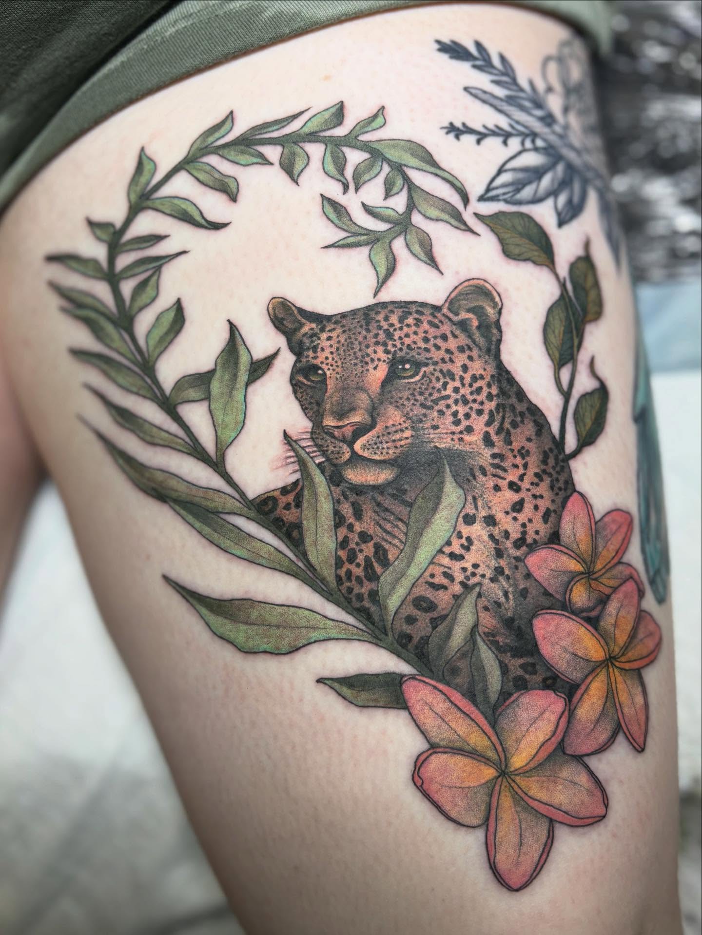 Jaguar with flowers realism tattoo on the thigh by Olivia Buch
