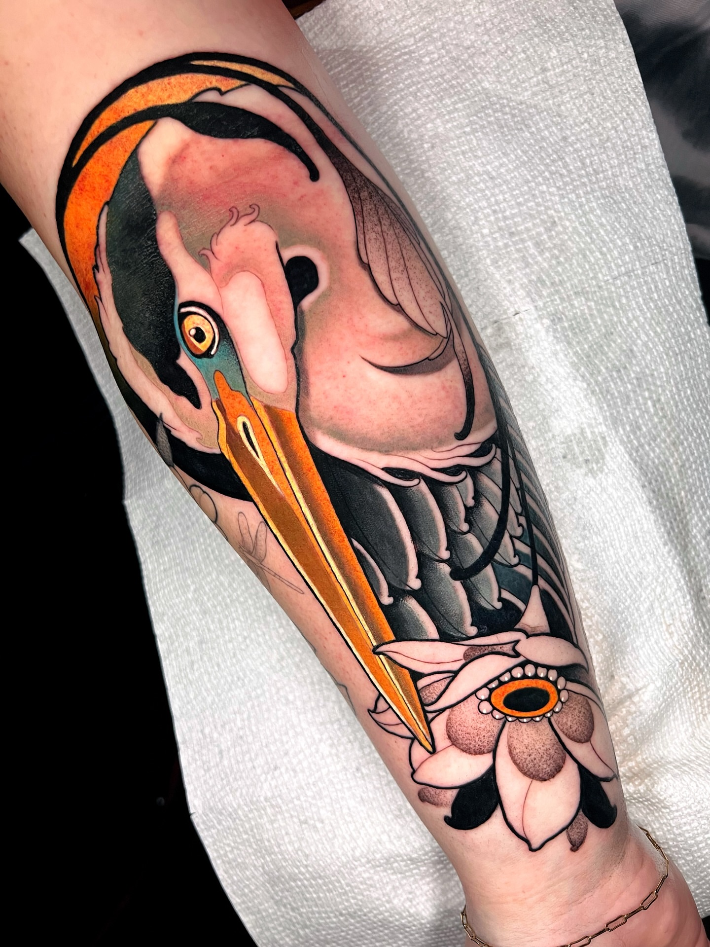 Pelican and flower American traditional tattoo on the forearm by Skyler Miller
