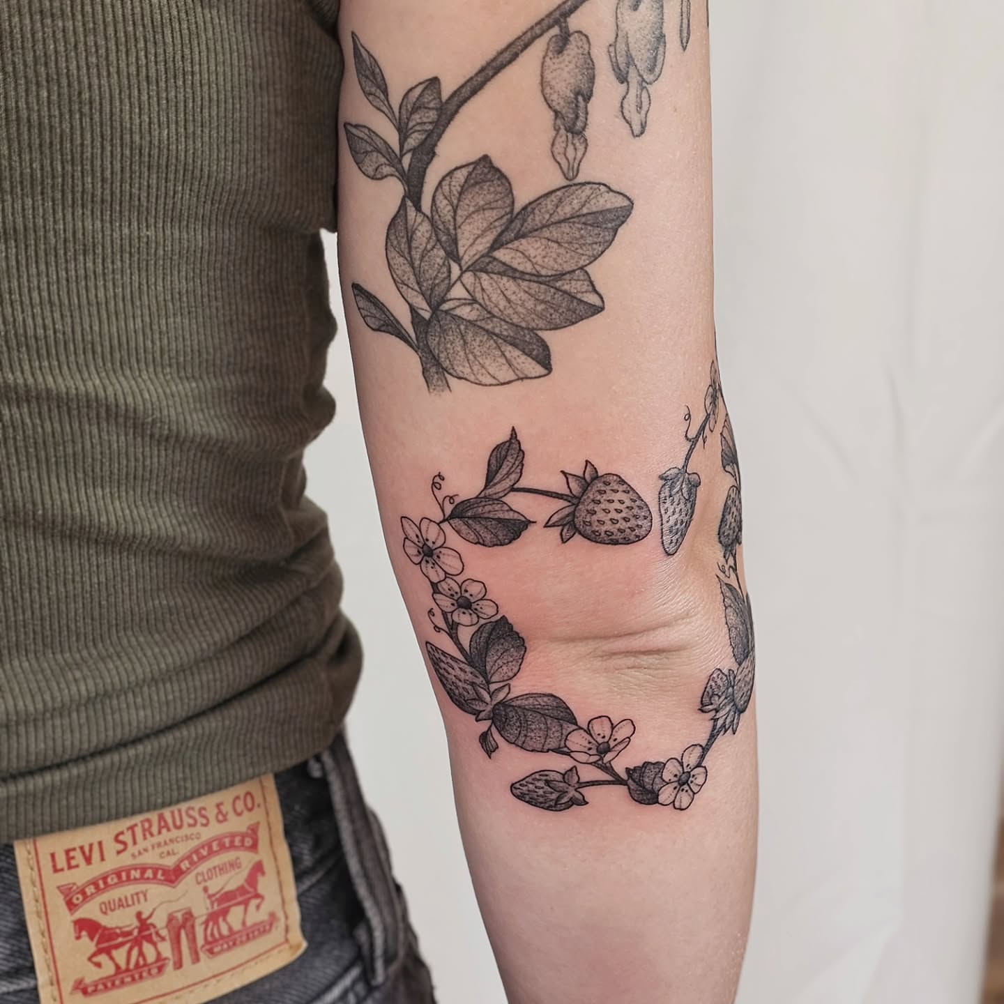 Strawberry wreath dotwork tattoo on the forearm by Kylie Lund