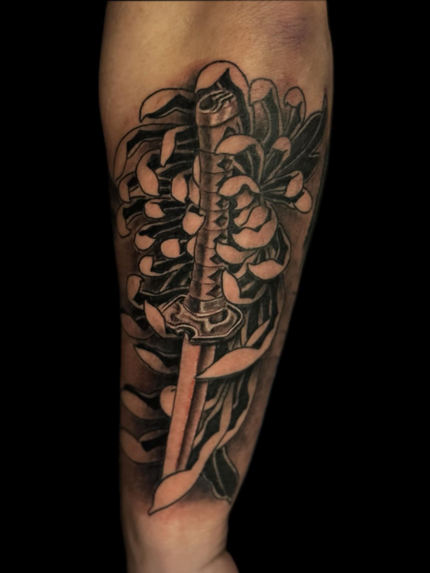 Sword and flowers realism tattoo on the forearm by Jacob Bettker, Centerville, Ohio