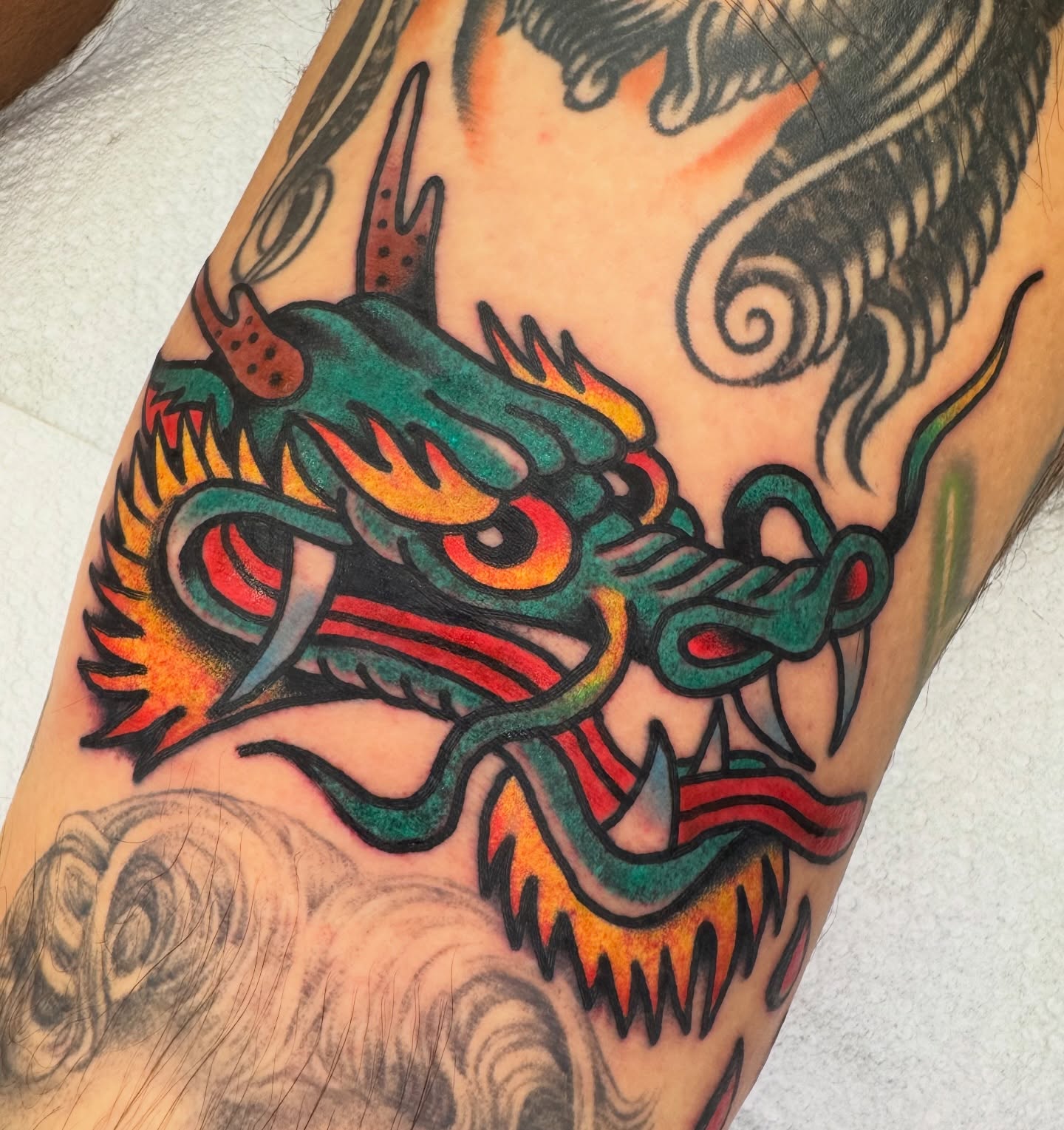 Dragon head American traditional tattoo on the forearm by Kenny Kastro