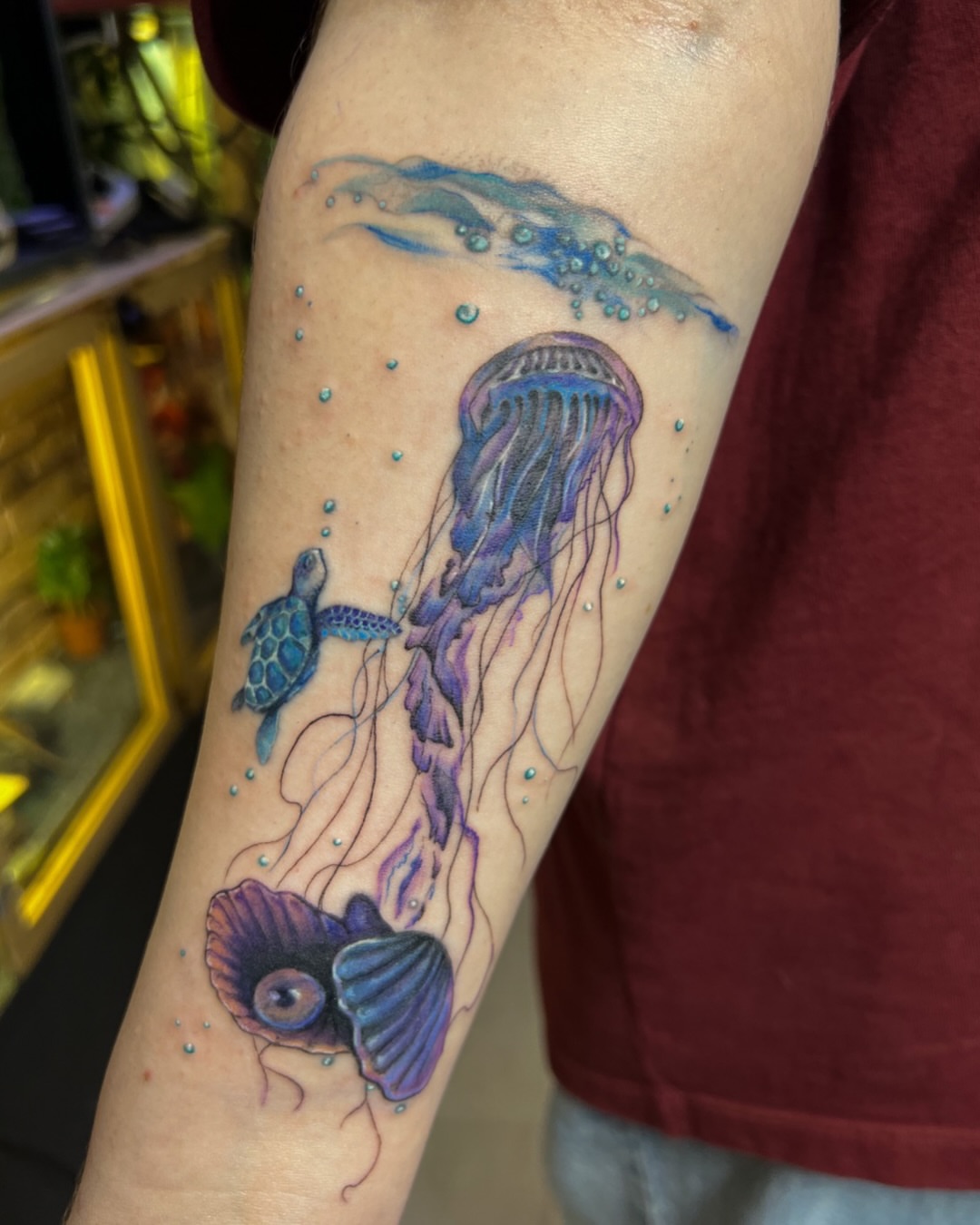 Jellyfish and turtle watercolor tattoo on the forearm by Asap tattoo