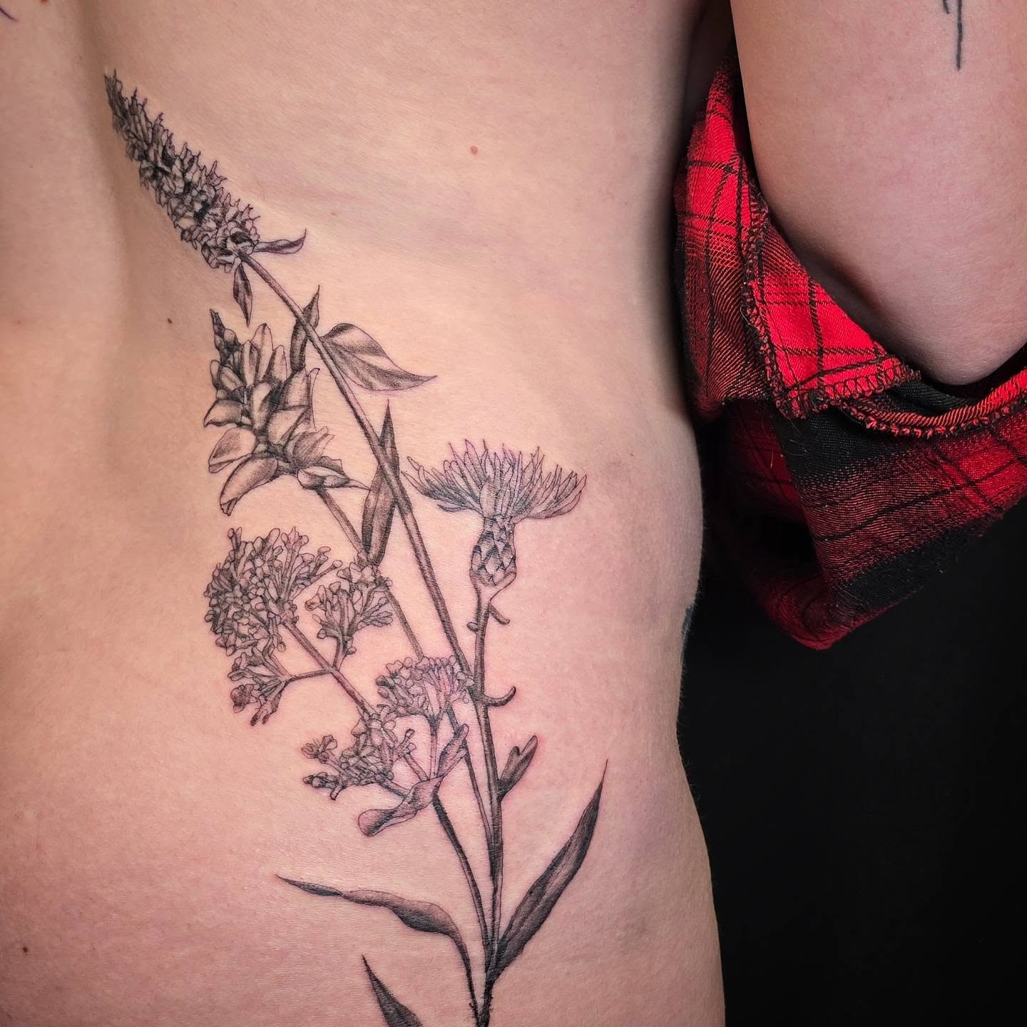 Flower arrangement black and grey tattoo on the ribs by Linda Marroum, Morningside, Maryland