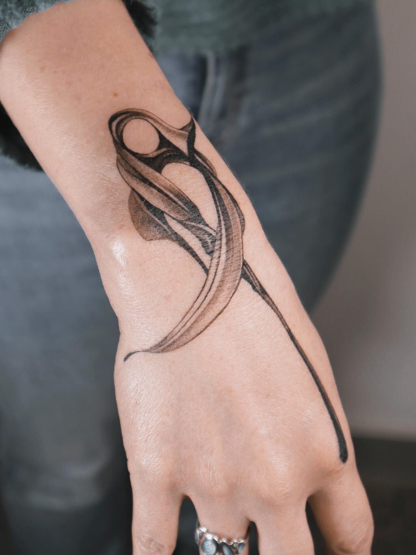Abstract swirl black and grey tattoo on the hand by River, New York, New York