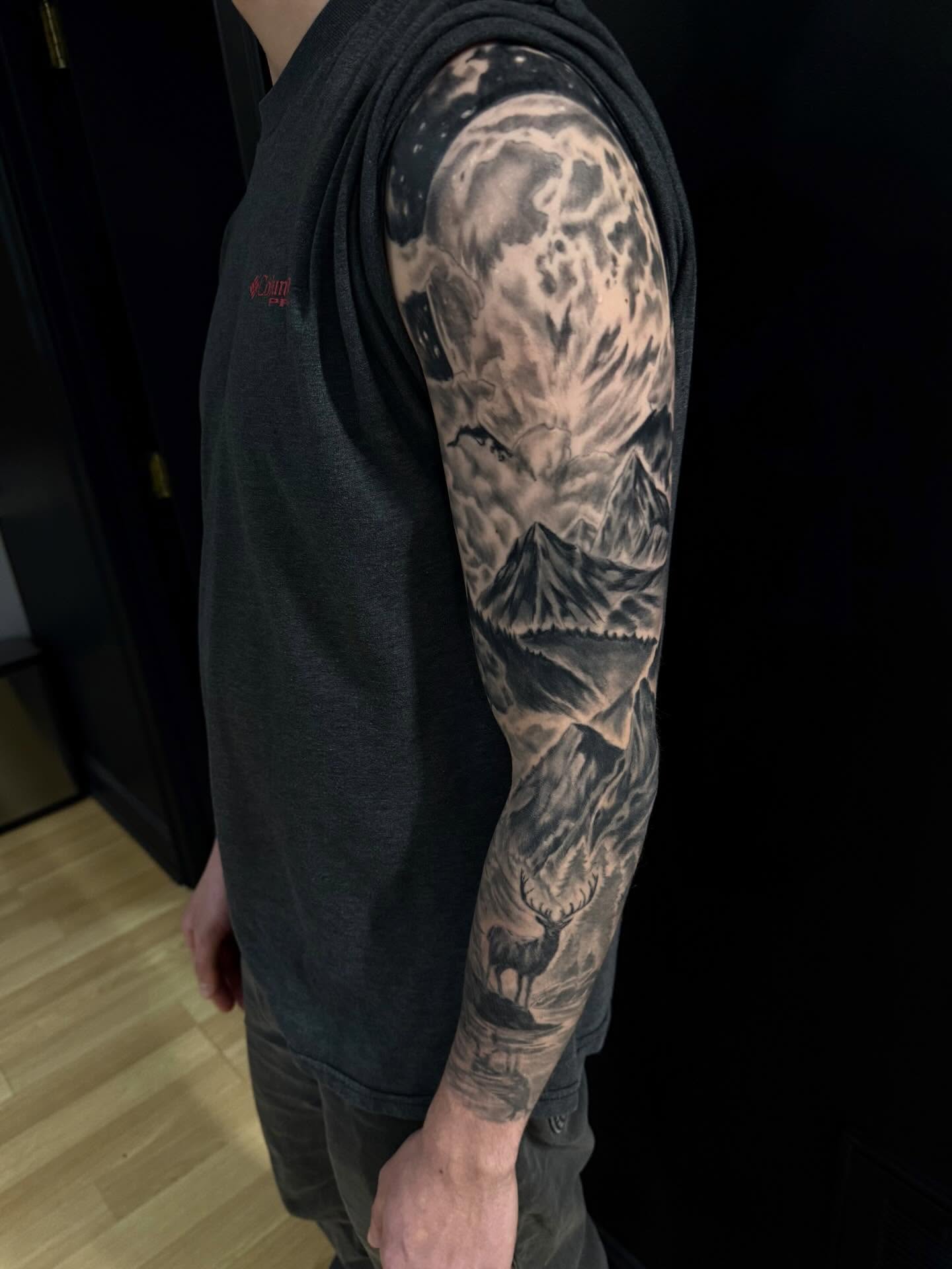 Mountain landscape realism tattoo on the upper arm by Tyler Bolton