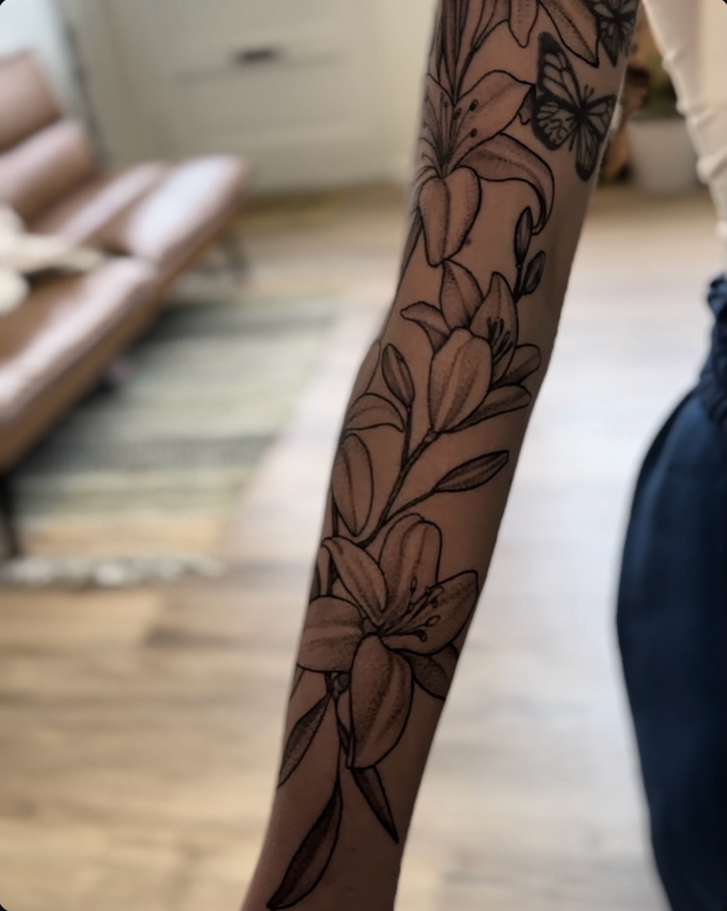 Lilies black and grey tattoo on the forearm by Allexis