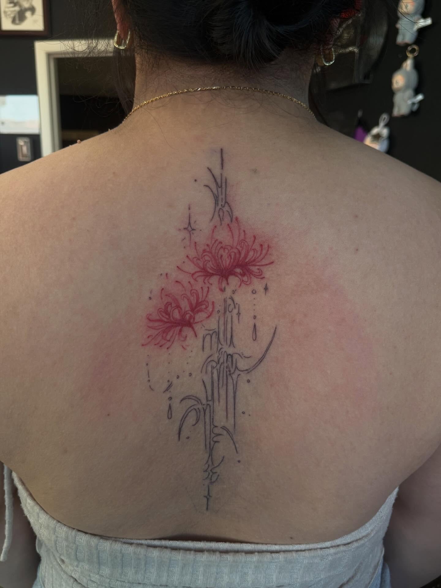 Chrysanthemum bouquet dotwork tattoo on the back by Rachel Hanke