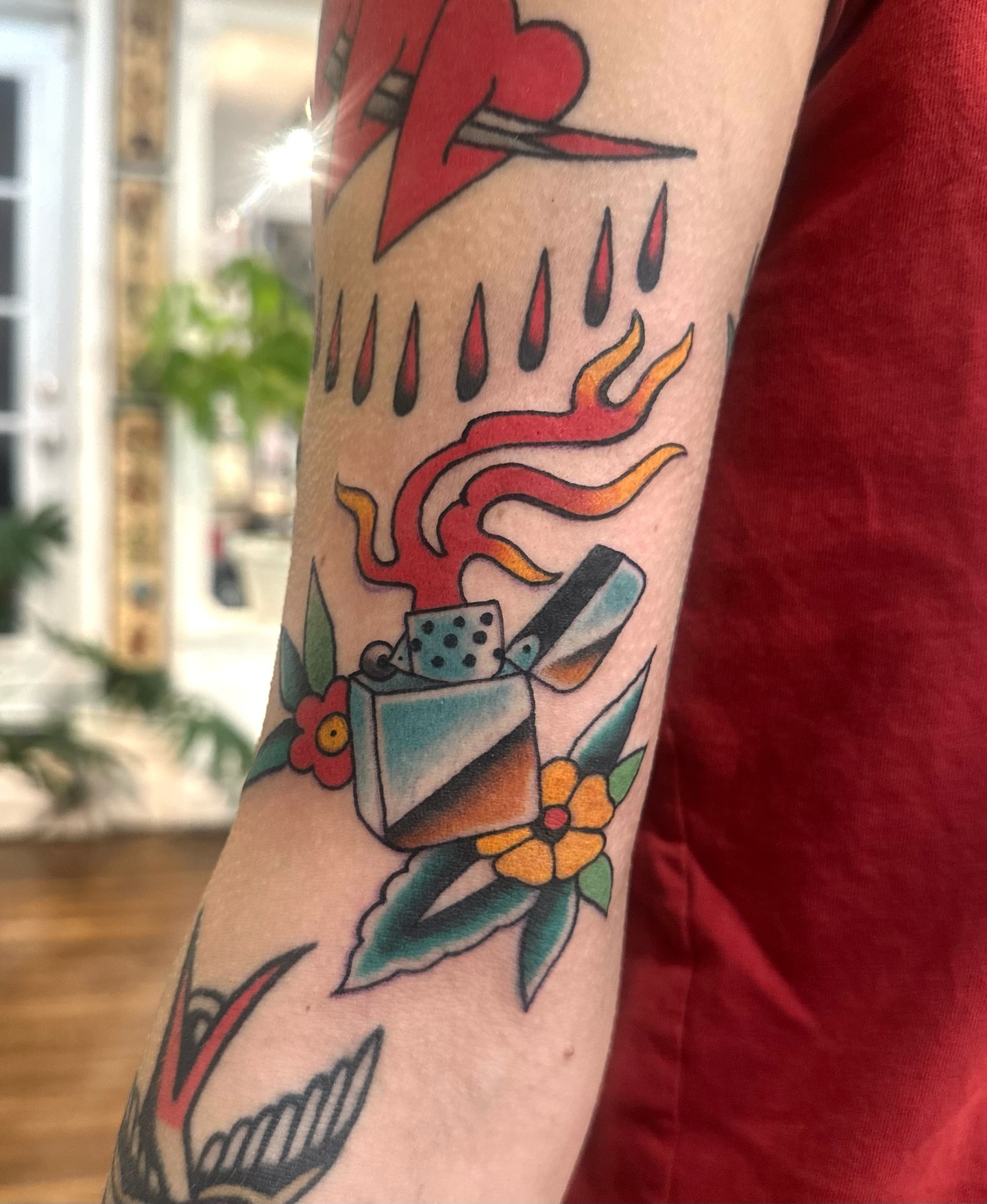 Lighter and flames American traditional tattoo on the forearm by Stacy Fevinger