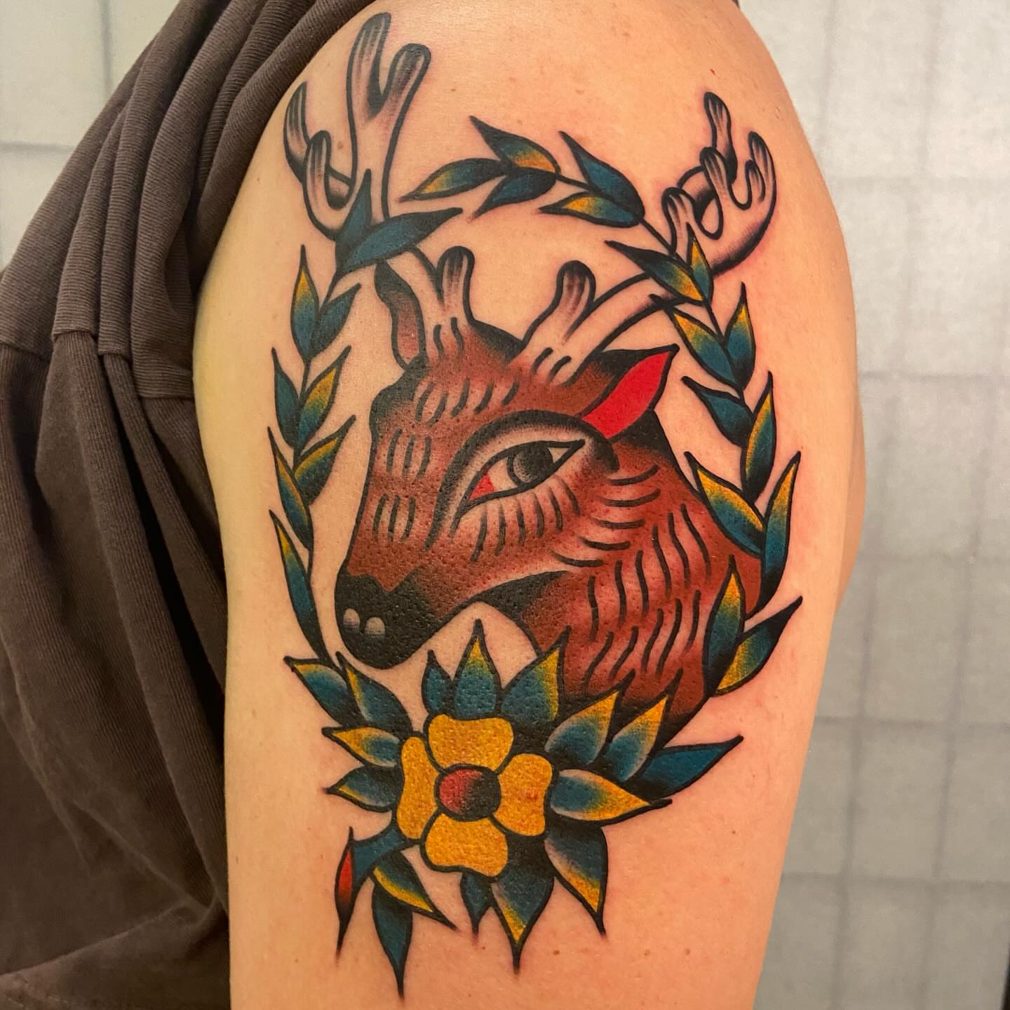 Deer head with floral wreath American traditional tattoo on the shoulder by Anthony Jaeger, Seattle, Washington