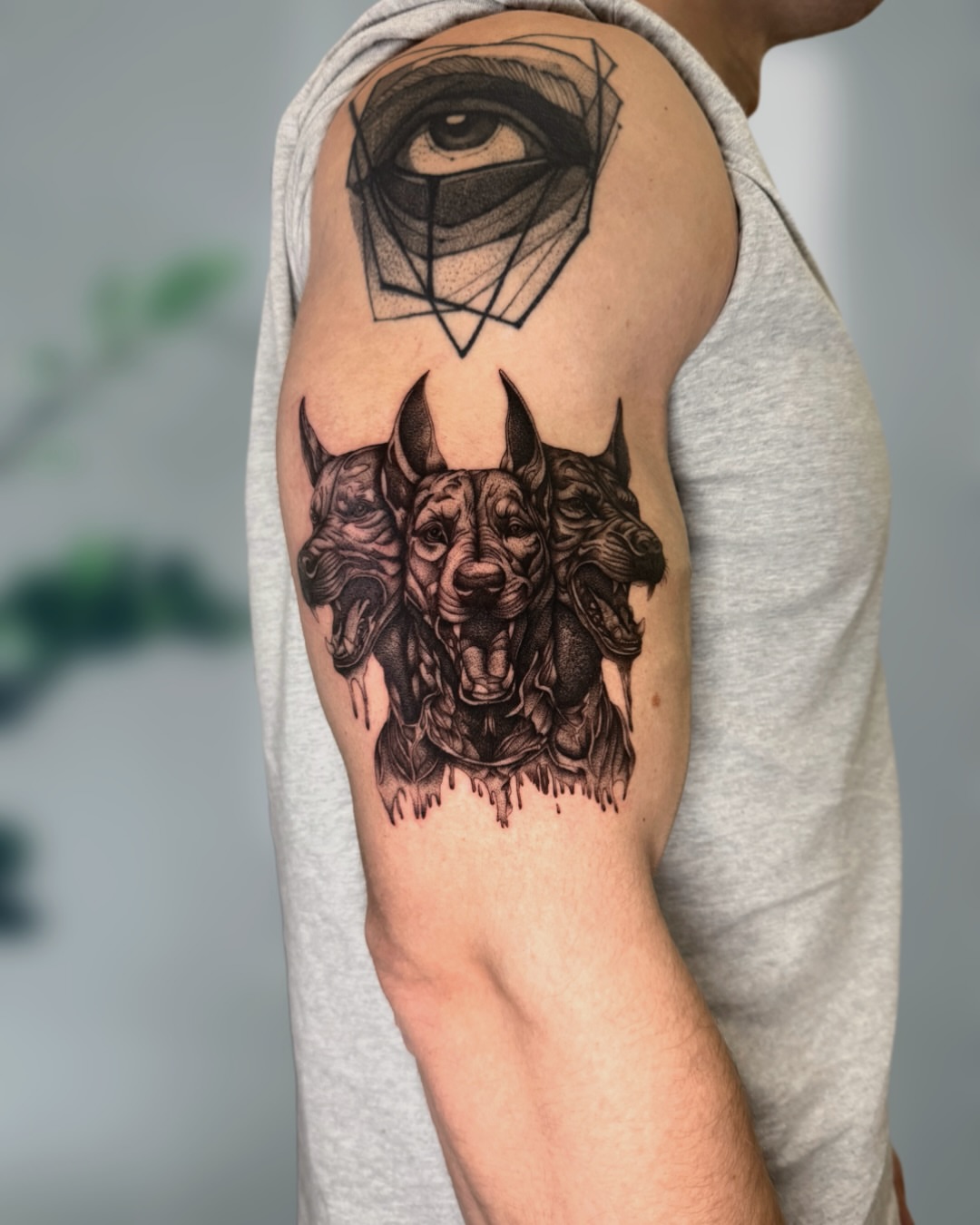 Wolf heads geometric tattoo on the upper arm by Ingrid Rojas