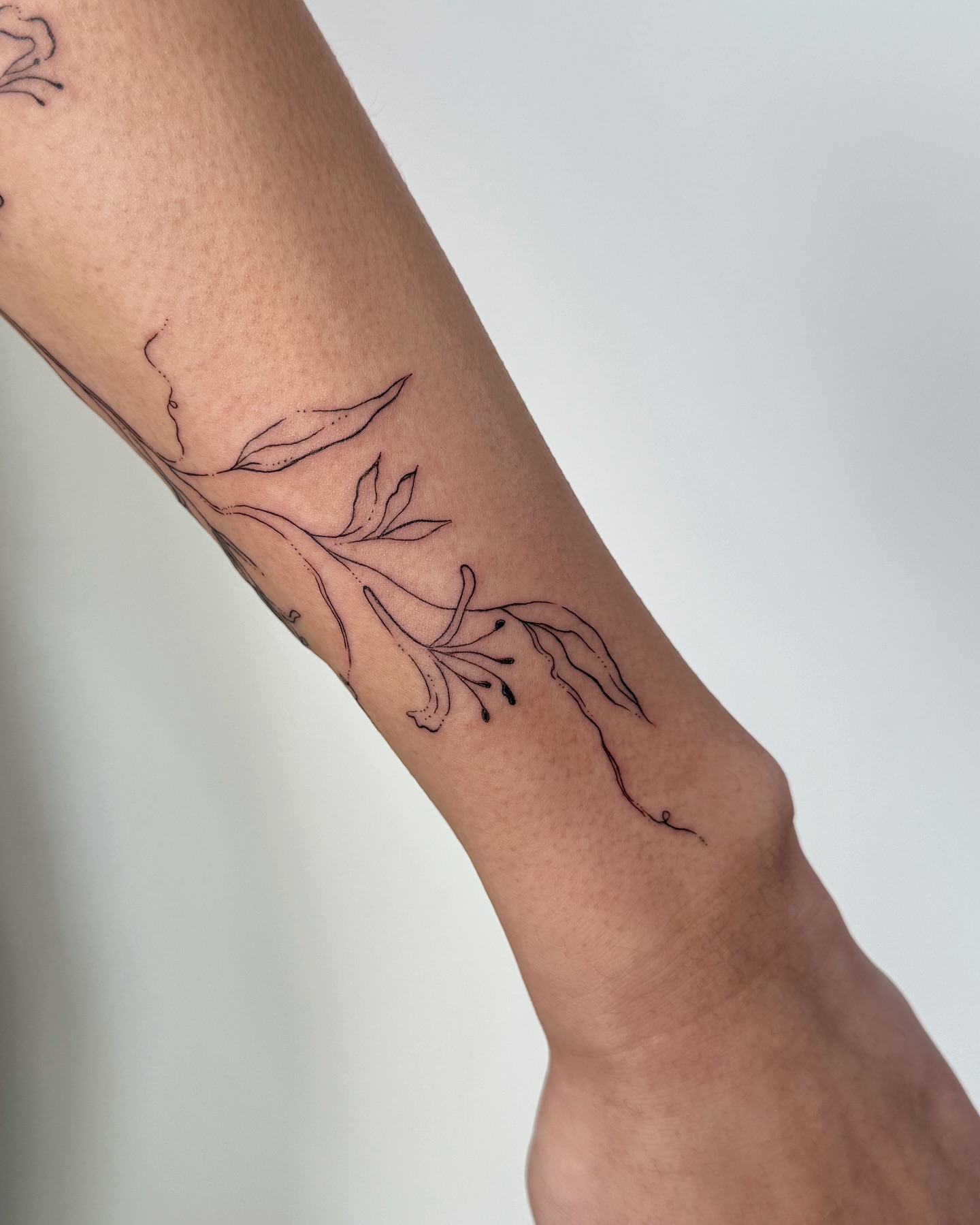 Flower fine line tattoo on the forearm by Inky Apricot, Austin, Texas