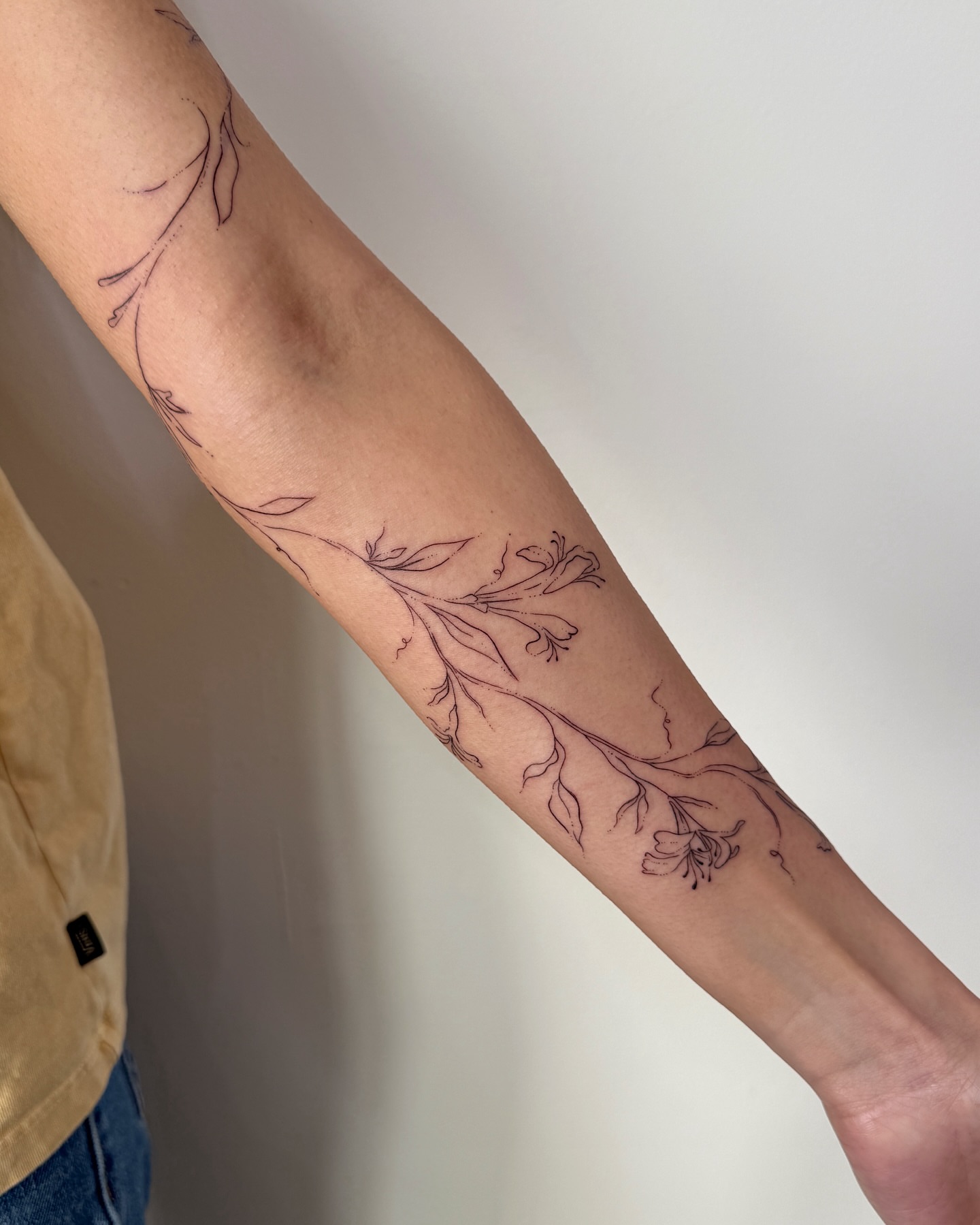 Floral branch fine line tattoo on the forearm by Inky Apricot, Austin, Texas