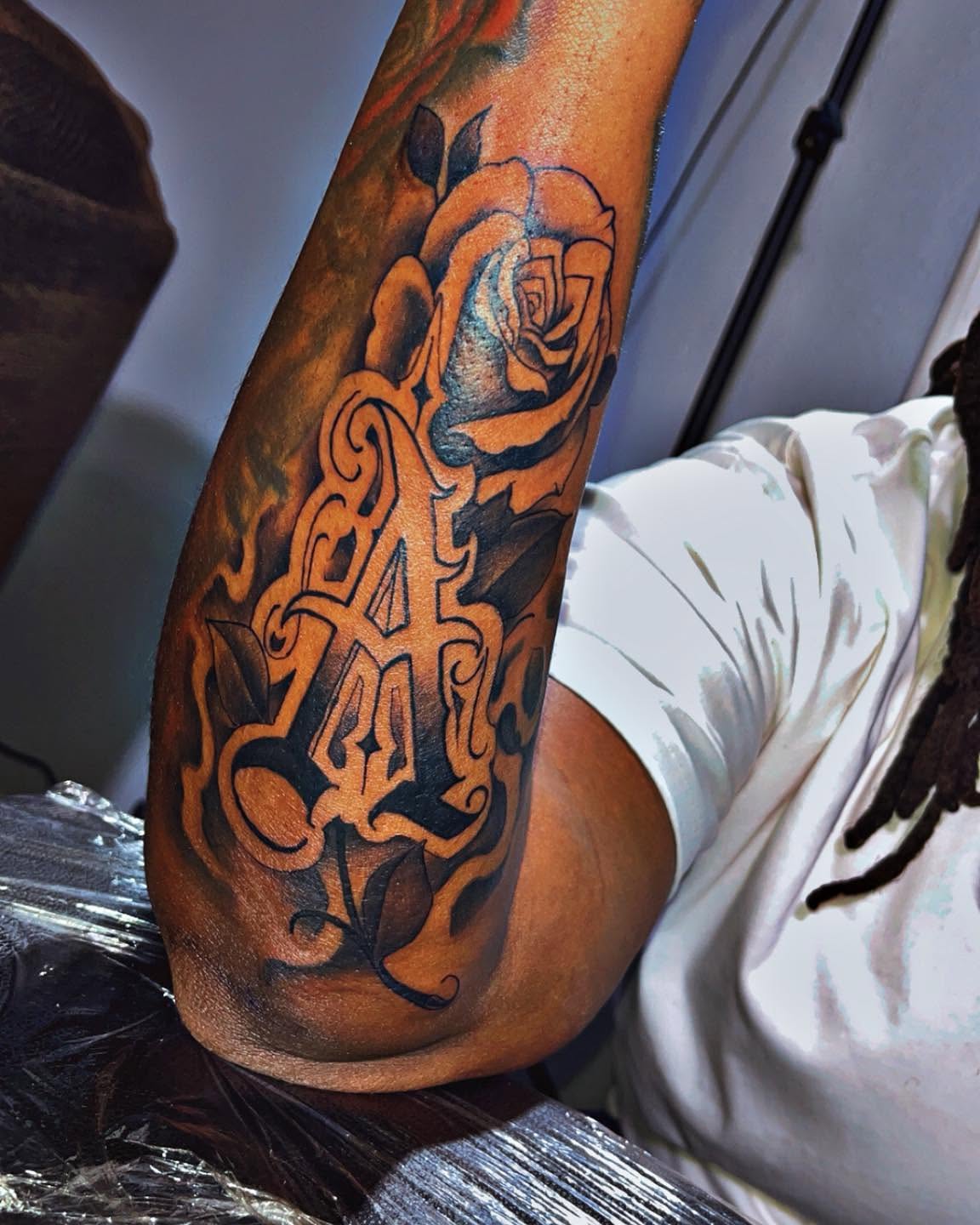 Rose and monogram black and grey tattoo on the forearm by Ferlandis Fitch, Long Beach, California