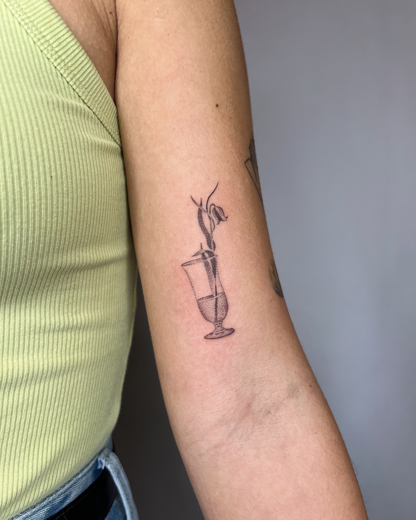 Glass with plant black and grey tattoo on the forearm by kait ❃ hartman