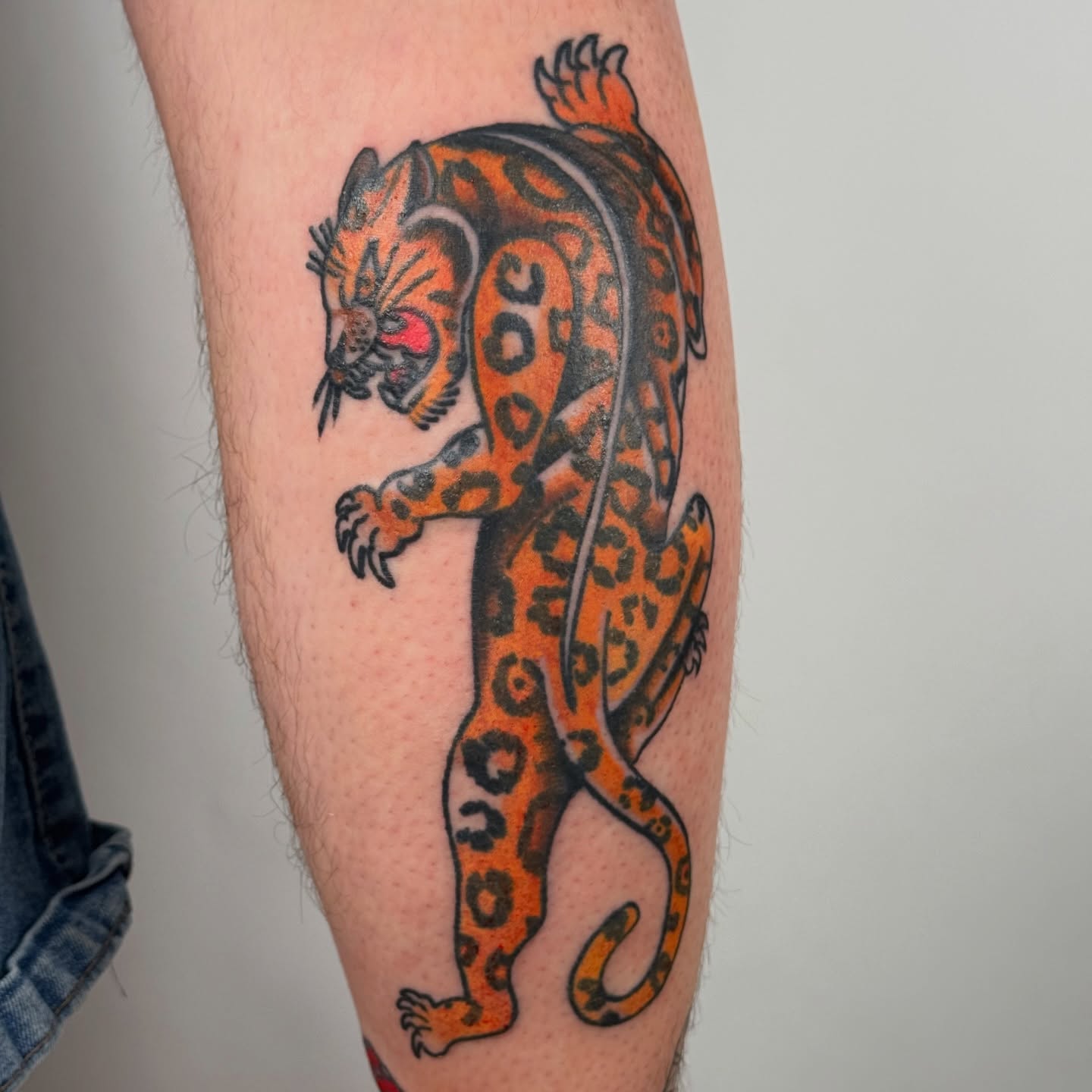 Jaguar American traditional tattoo on the forearm by autumn sky
