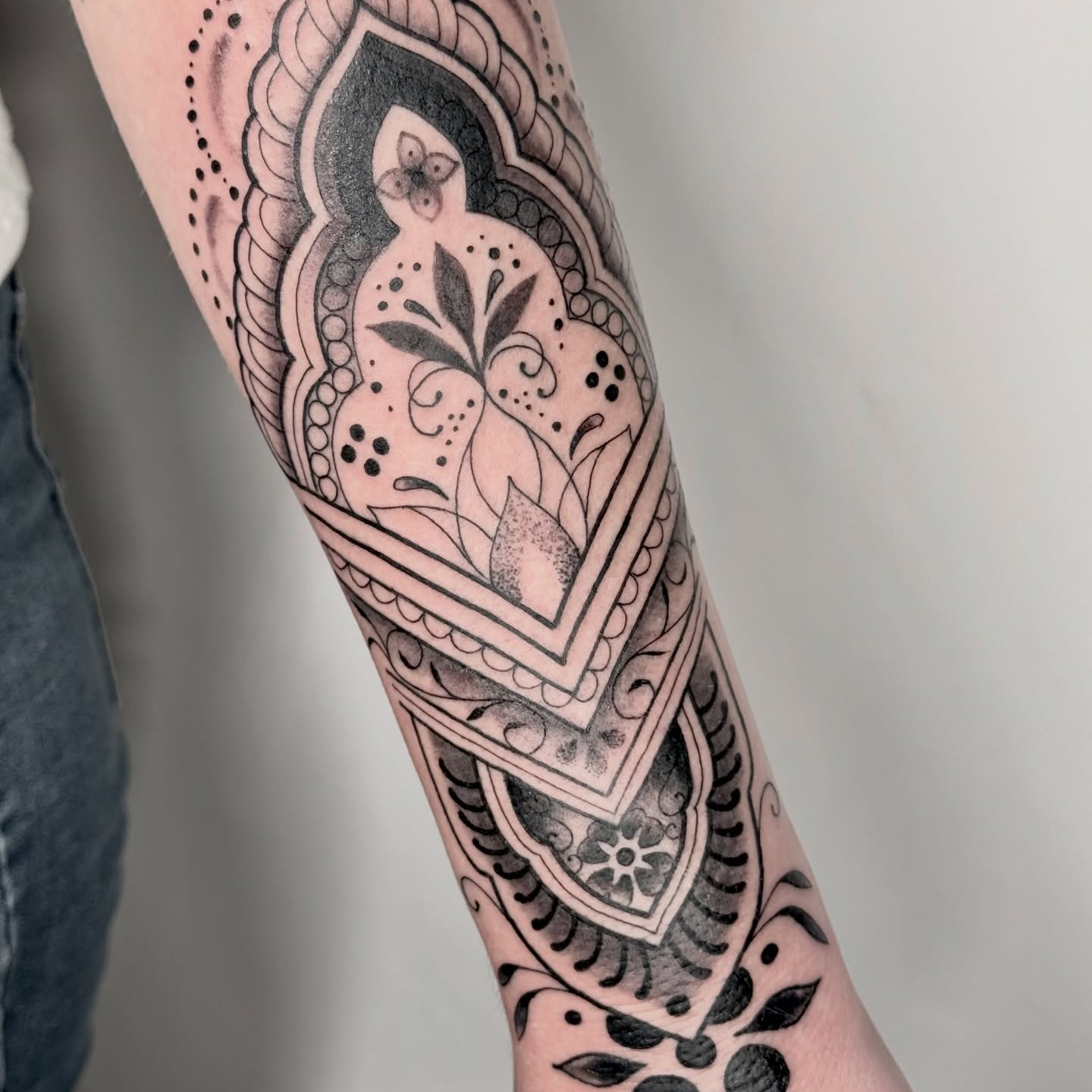 Pomegranate black and grey tattoo on the forearm by autumn sky