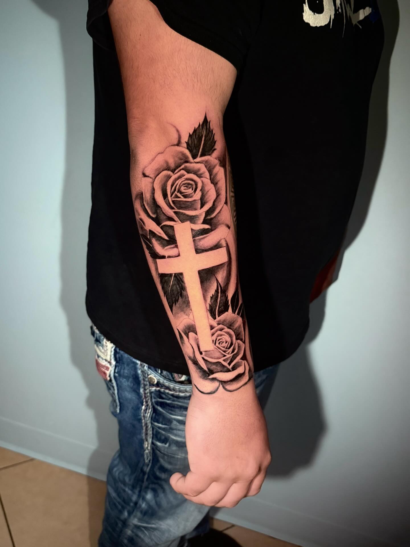 Cross and roses black and grey tattoo on the forearm by Stilow Memphis Tattoo Artist, Memphis, Tennessee