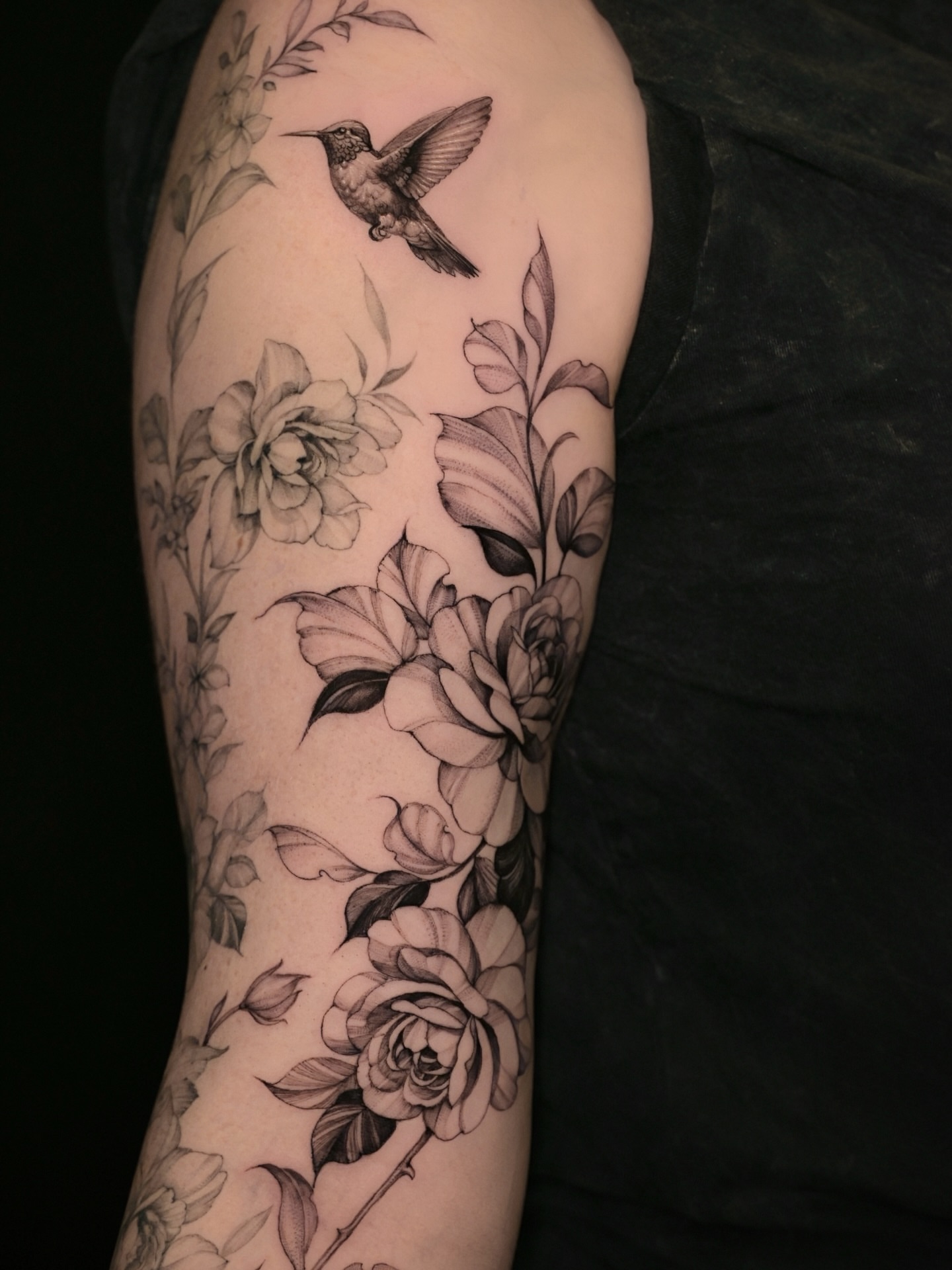 Flowers and hummingbird realism tattoo on the forearm by Zonghuan Wu