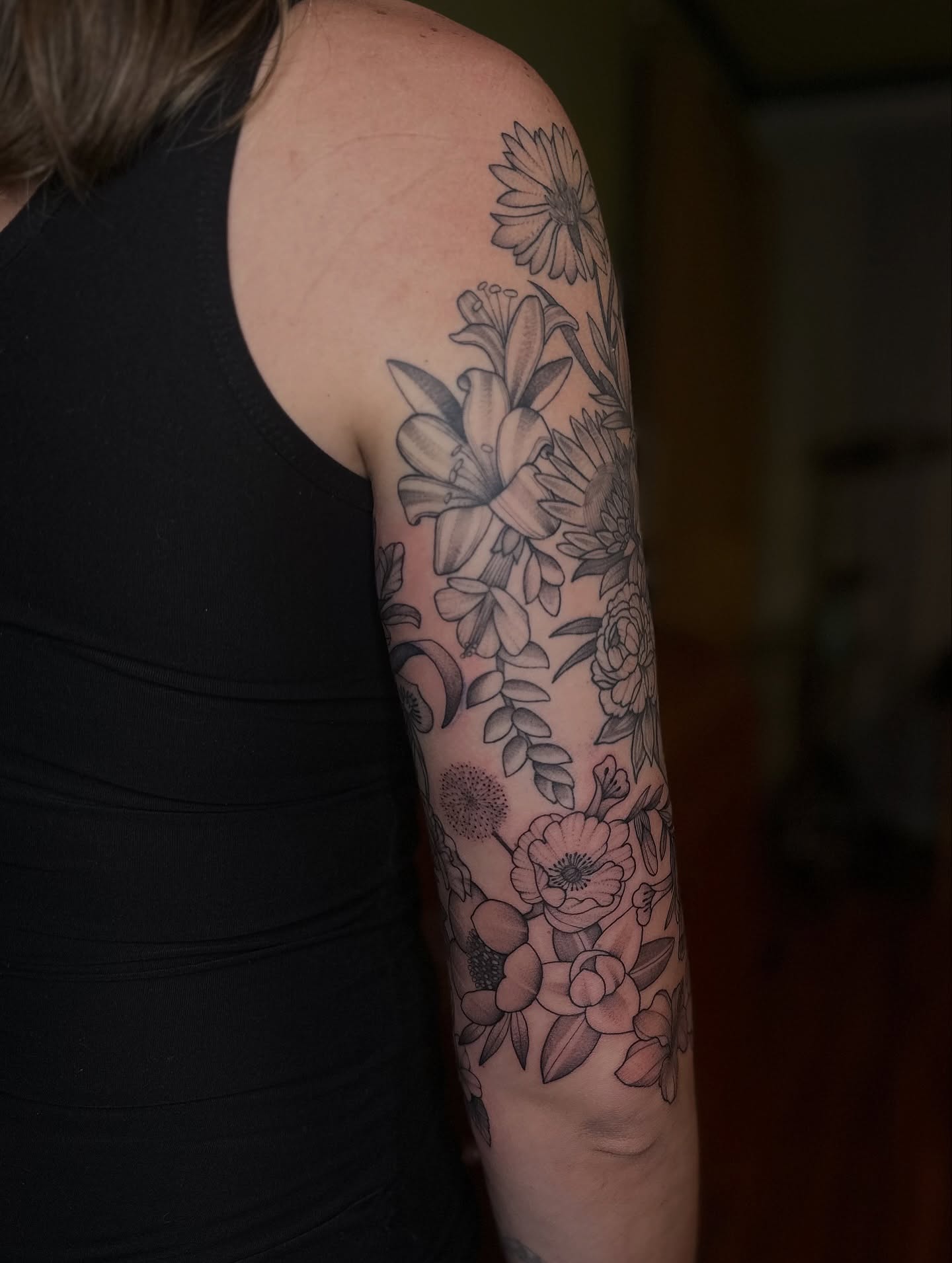 Floral arrangement black and grey tattoo on the forearm by Brieana Smith