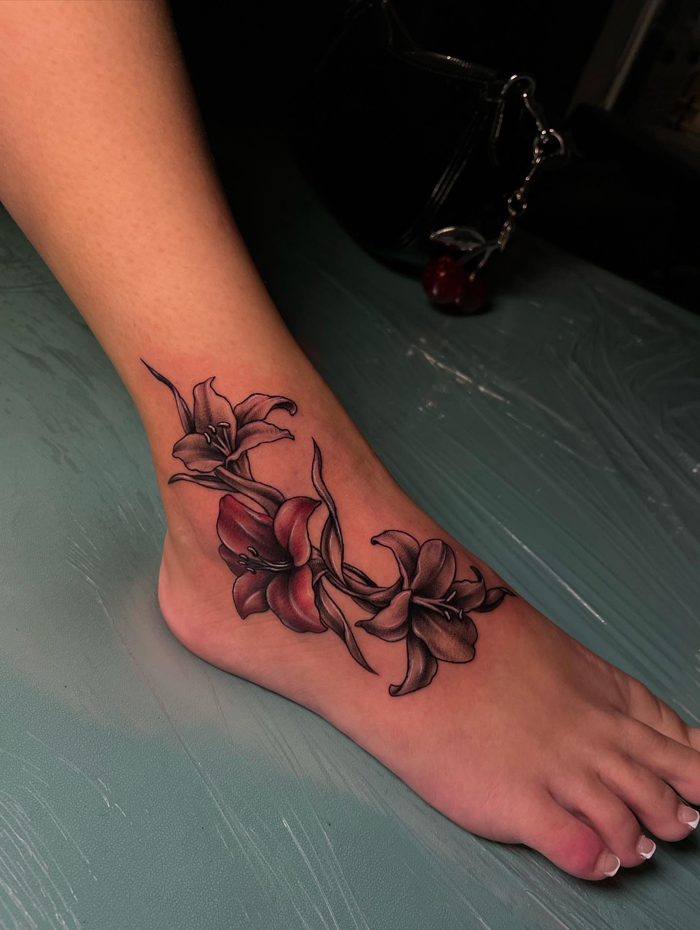 Lilies realism tattoo on the foot by Nikko