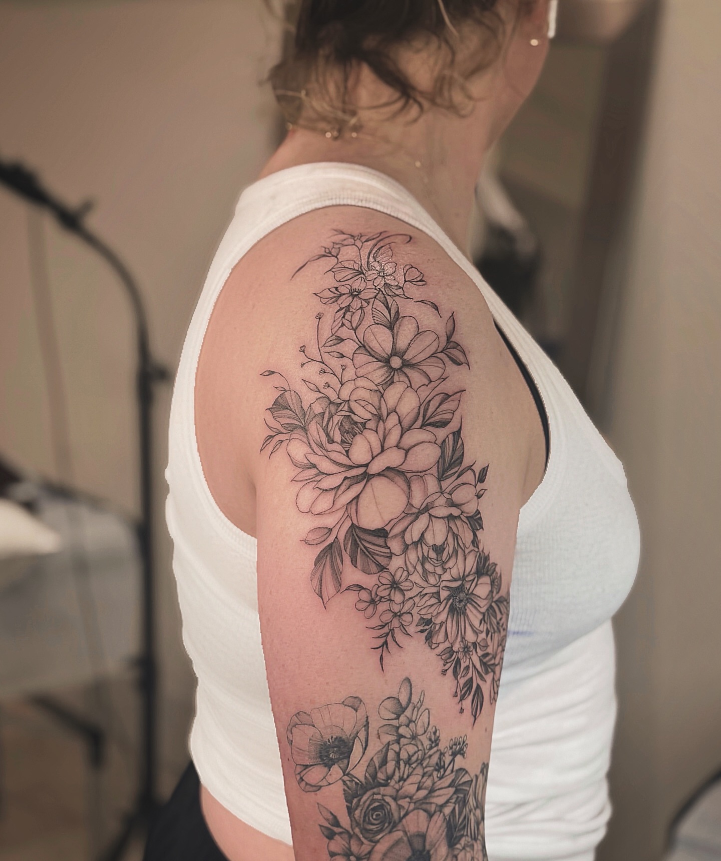 Floral bouquet black and grey tattoo on the upper arm by MJ