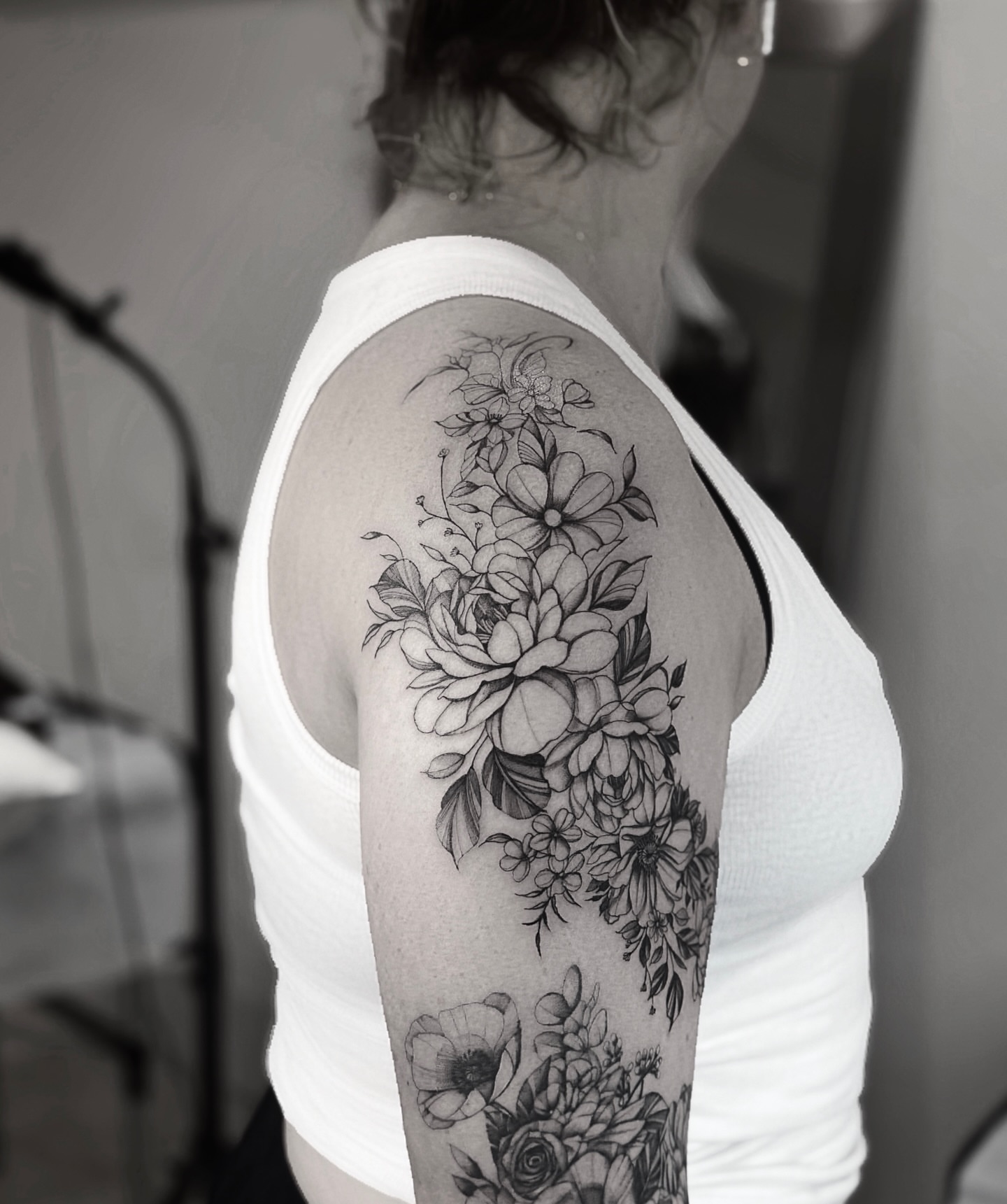 Floral bouquet black and grey tattoo on the upper arm by MJ