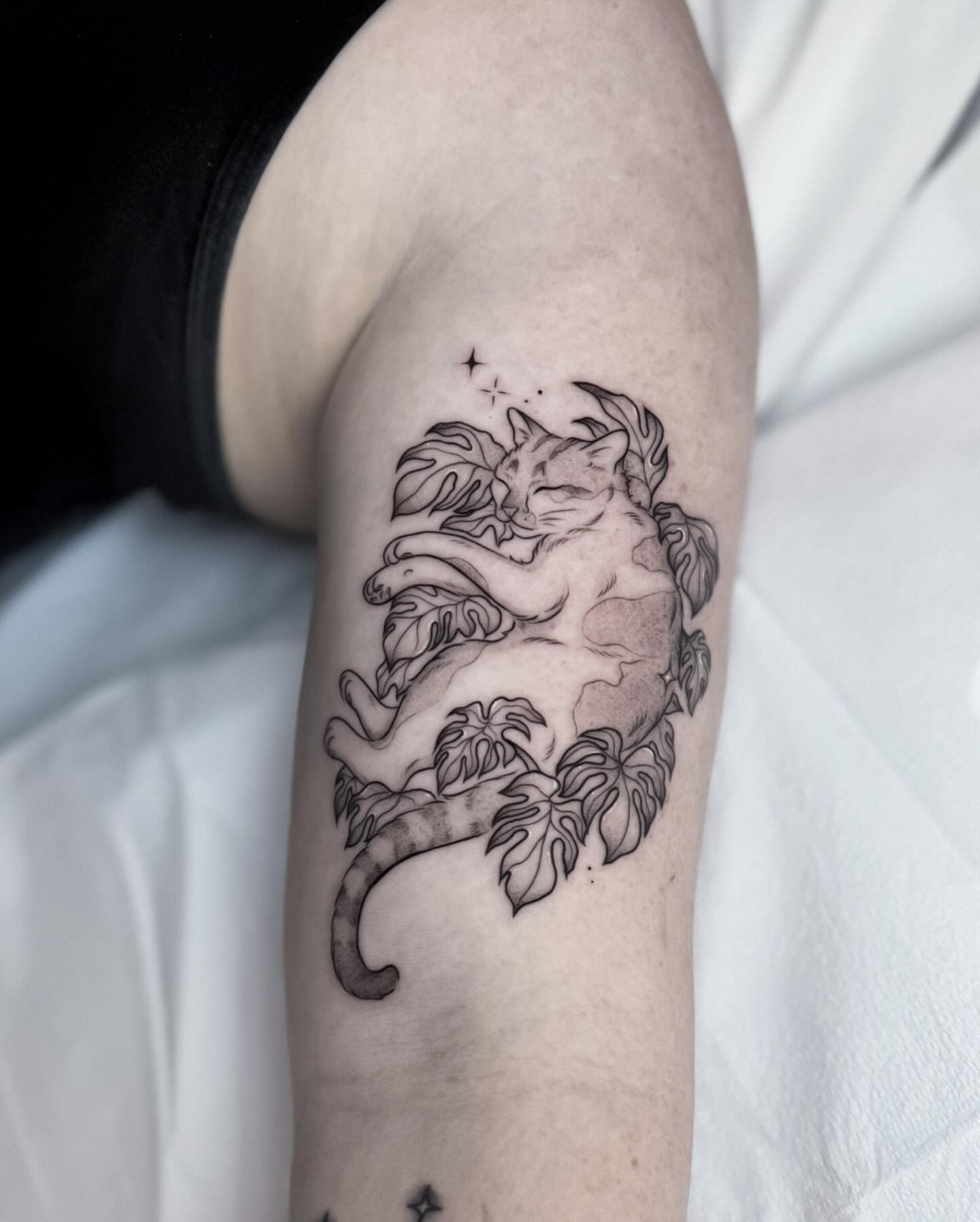 Cat and leaves black and grey tattoo on the forearm by Whimsical Tattoos
