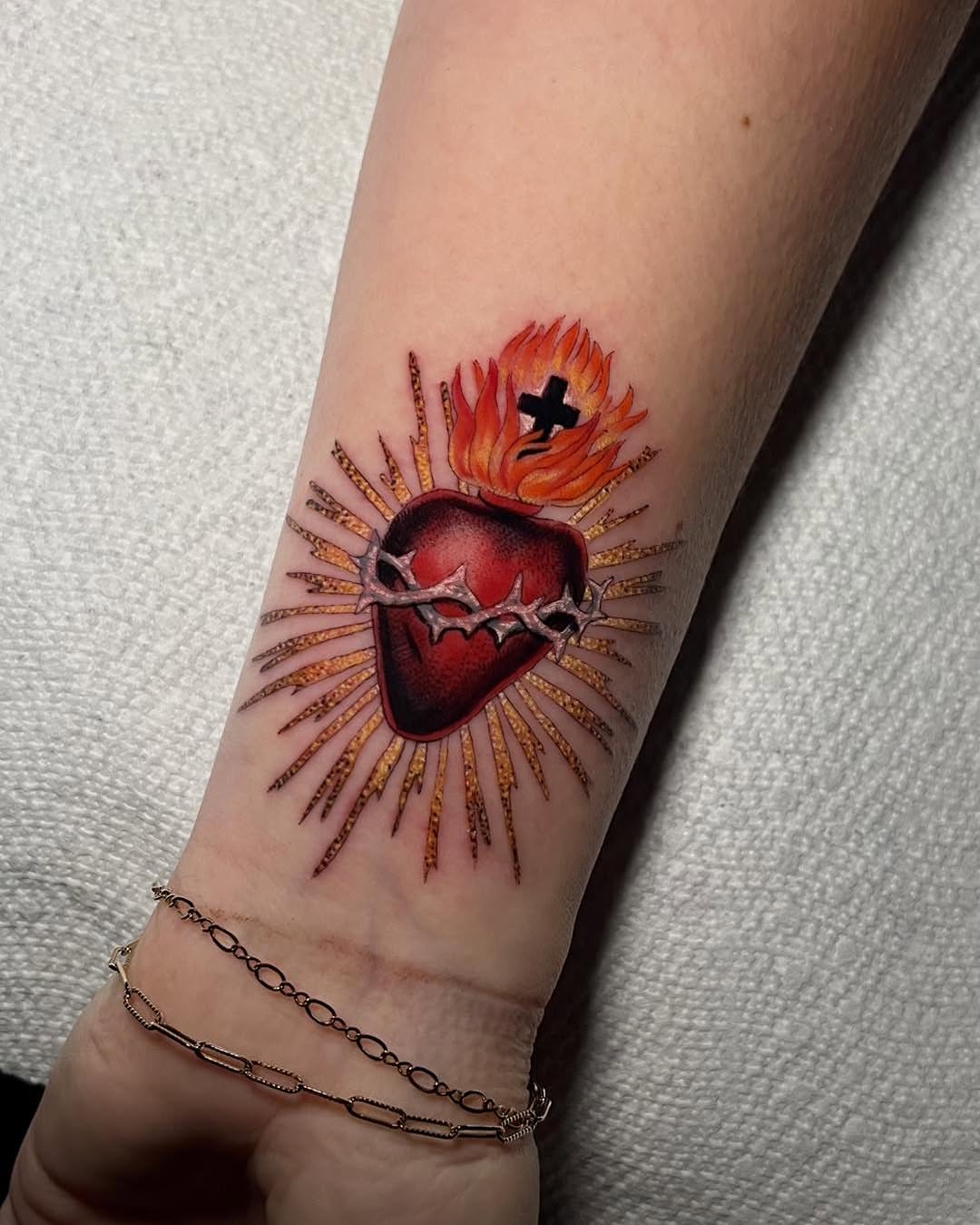 Heart with crown and flames realism tattoo on the forearm by Haylie Adele Strong