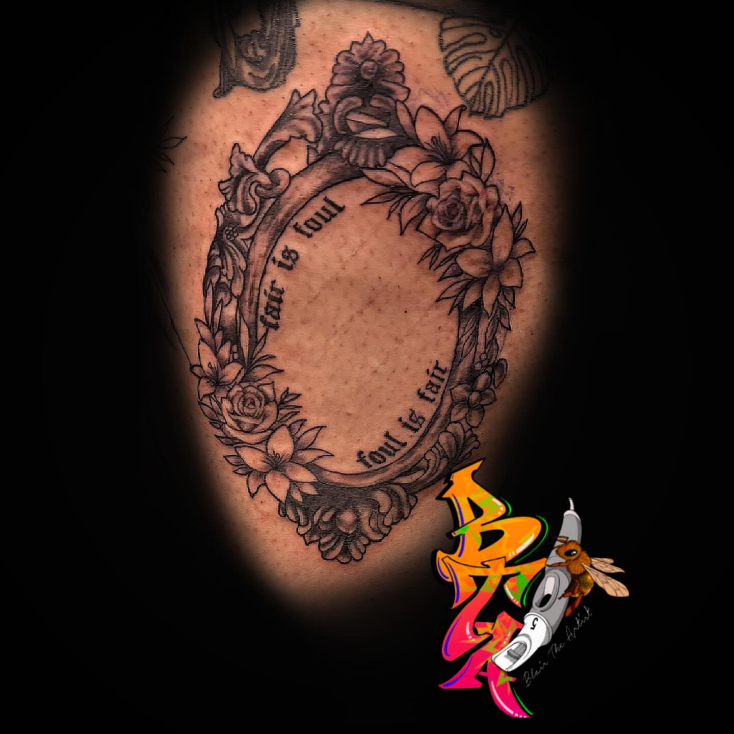 Oval frame with floral border black and grey tattoo on the thigh by Blair The Artist!