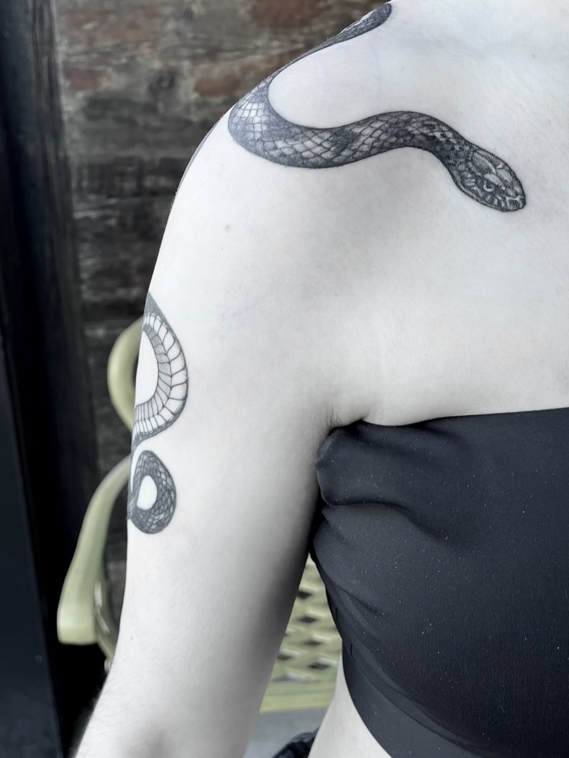 Snake black and grey tattoo on the shoulder by Nathan Esteras