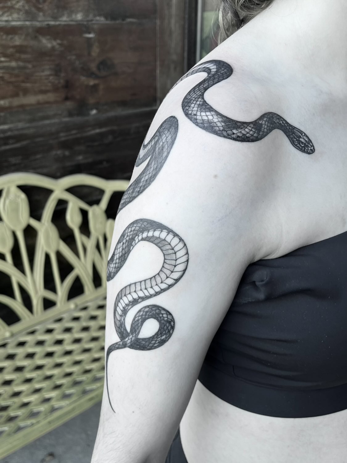 Snake black and grey tattoo on the upper arm by Nathan Esteras