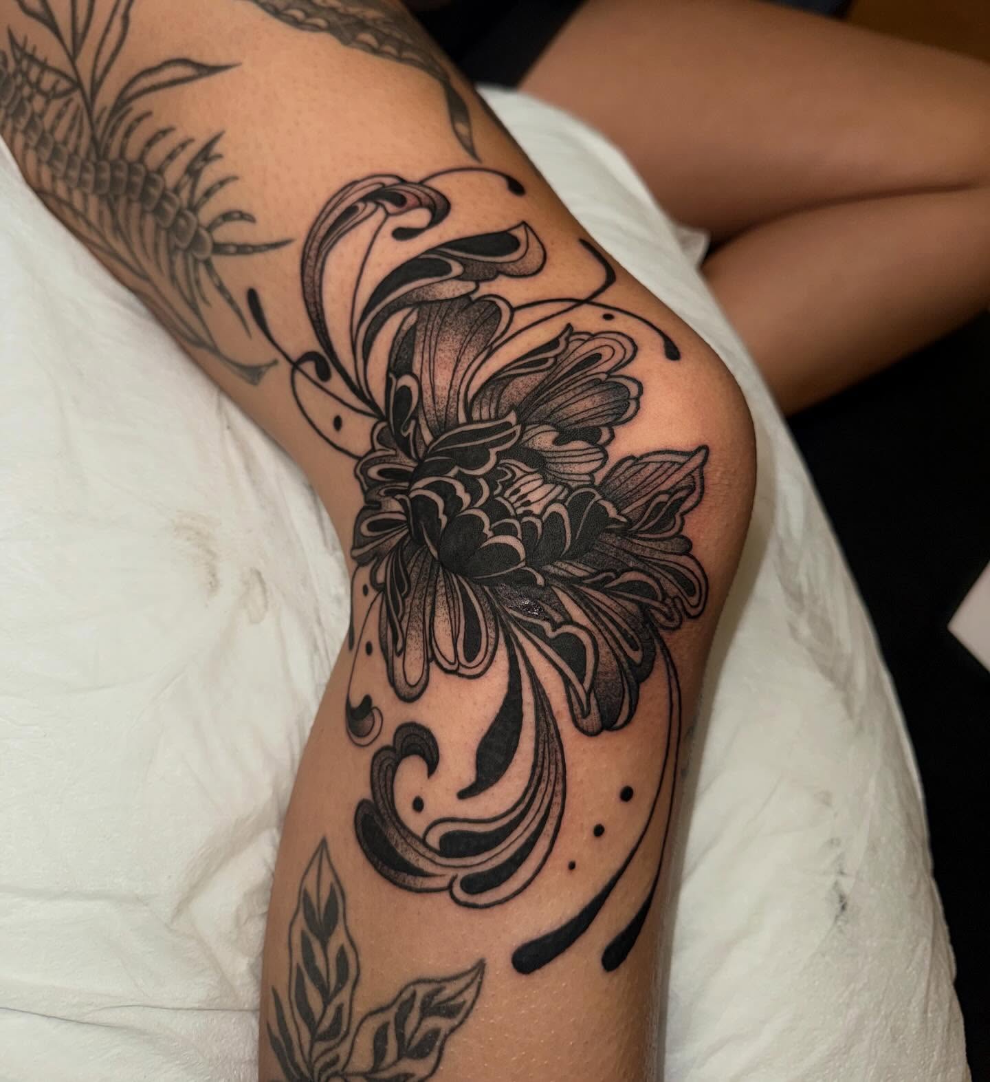 Floral design black and grey tattoo on the thigh by Laurito