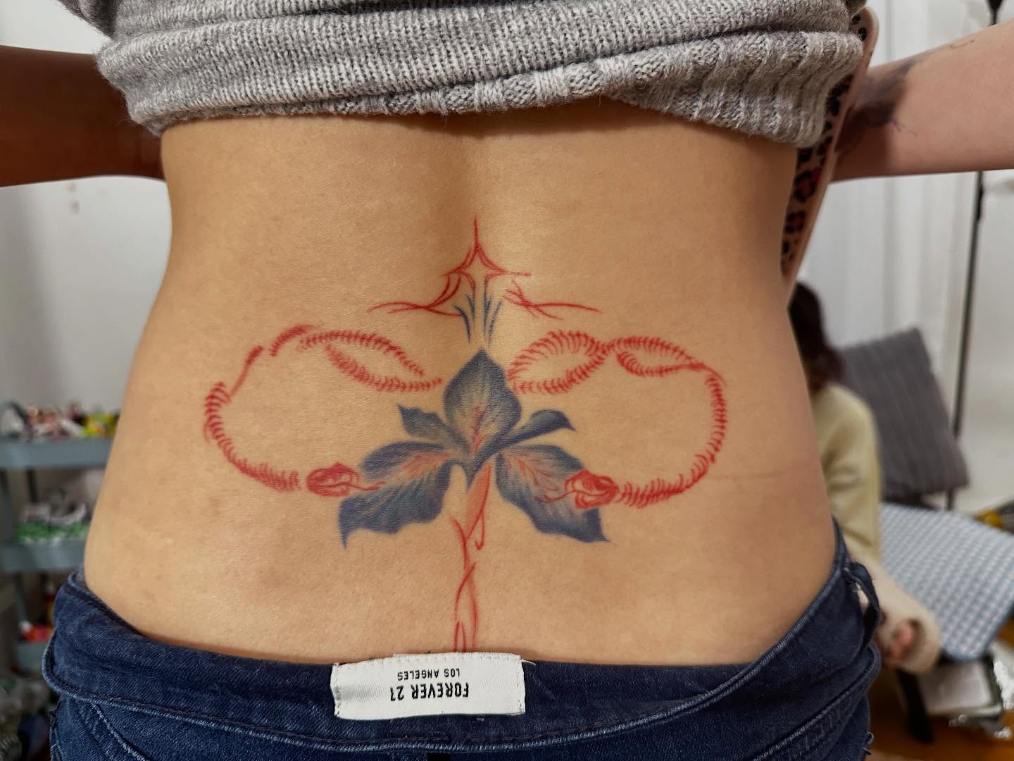 Iris flower geometric tattoo on the torso by Tomato