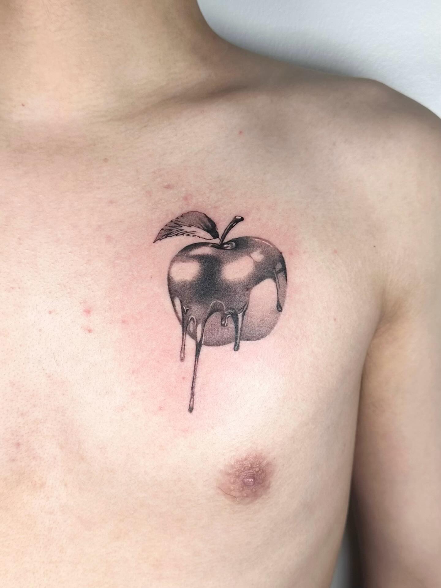 Apple black and grey tattoo on the chest by Tomato