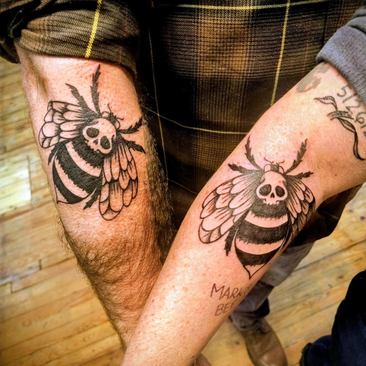 Bee black and grey tattoo on the forearm by Niki Jackson