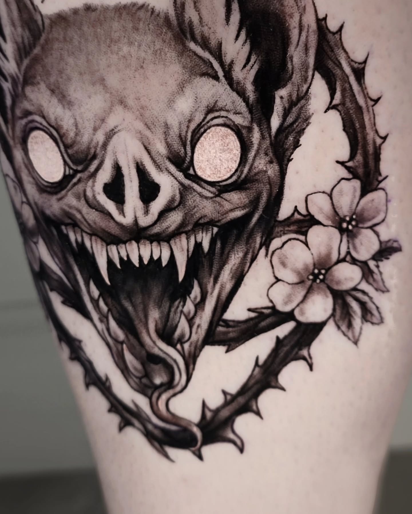 Demon head with flowers dark realism tattoo on the forearm by ʙʀɪᴀɴɴᴀ 𝒁𝑶𝑴𝑩𝑹𝑰𝑬 ᴛᴀᴛᴛᴏᴏꜱ