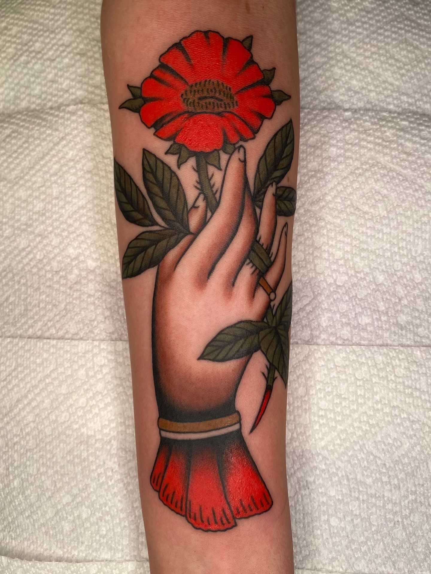Hand holding flower American traditional tattoo on the forearm by Will Allan Columbus tattoo artist