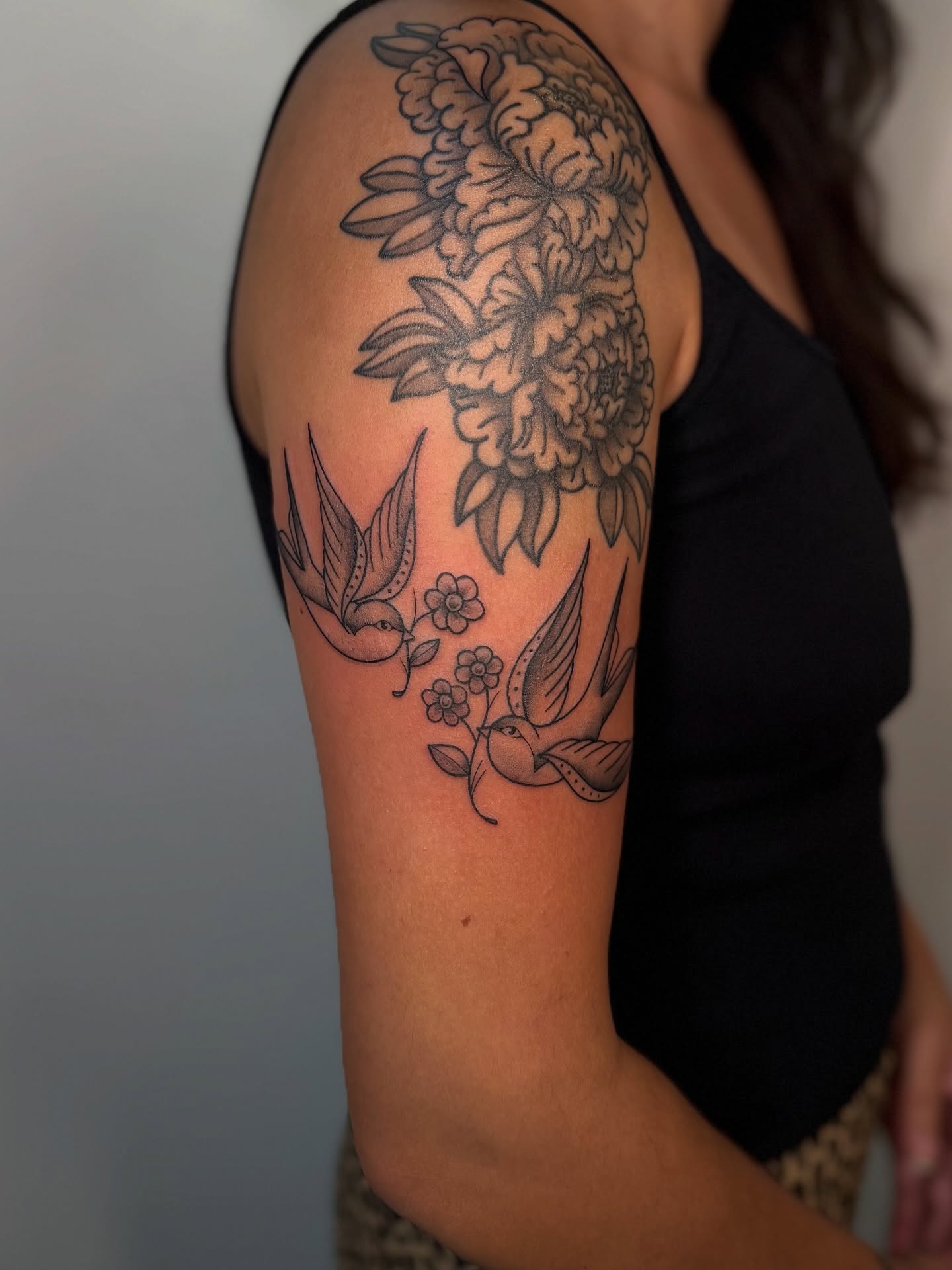 Flowers and birds black and grey tattoo on the upper arm by Kail