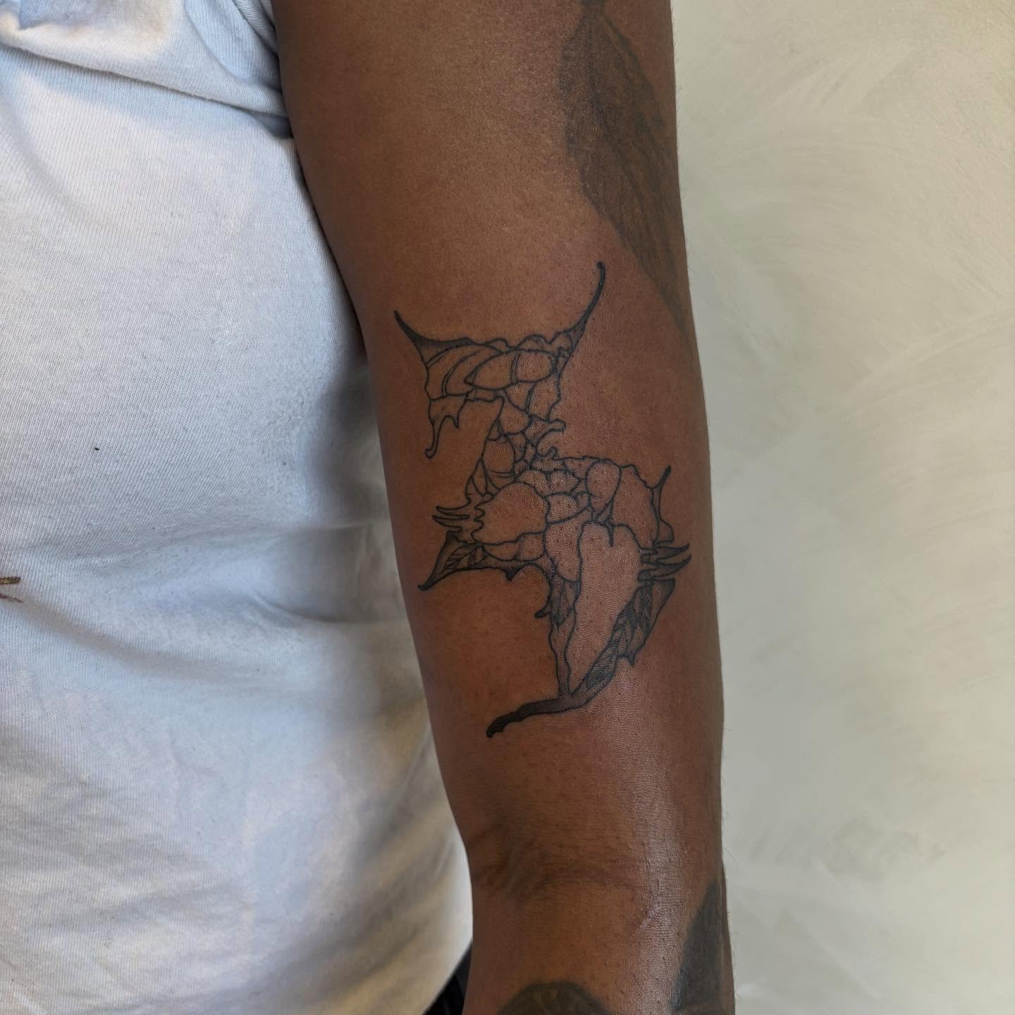 Abstract floral black and grey tattoo on the forearm by Dallas Davis